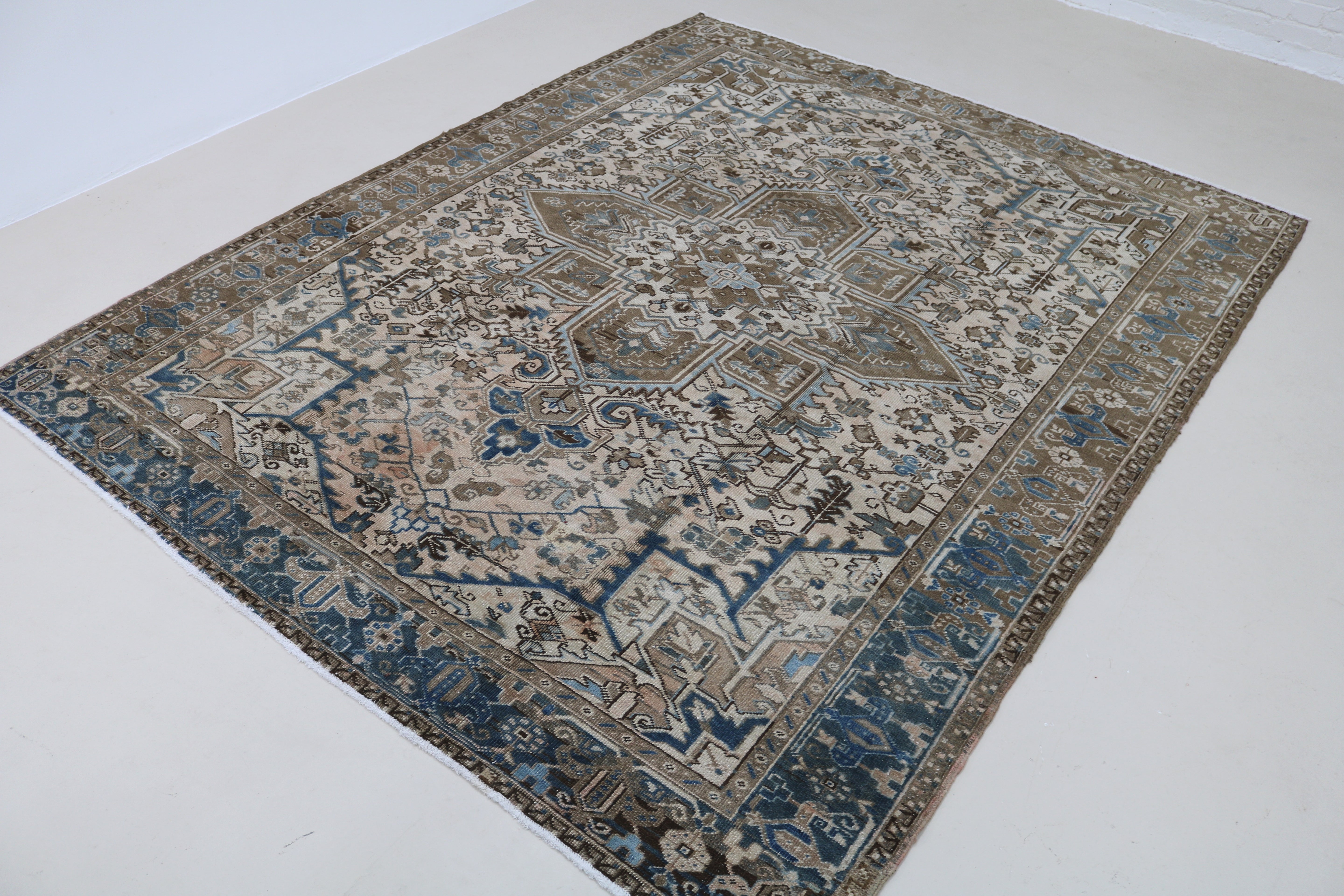 Angled view of decorative antique Heriz carpet highlighting overall pattern
