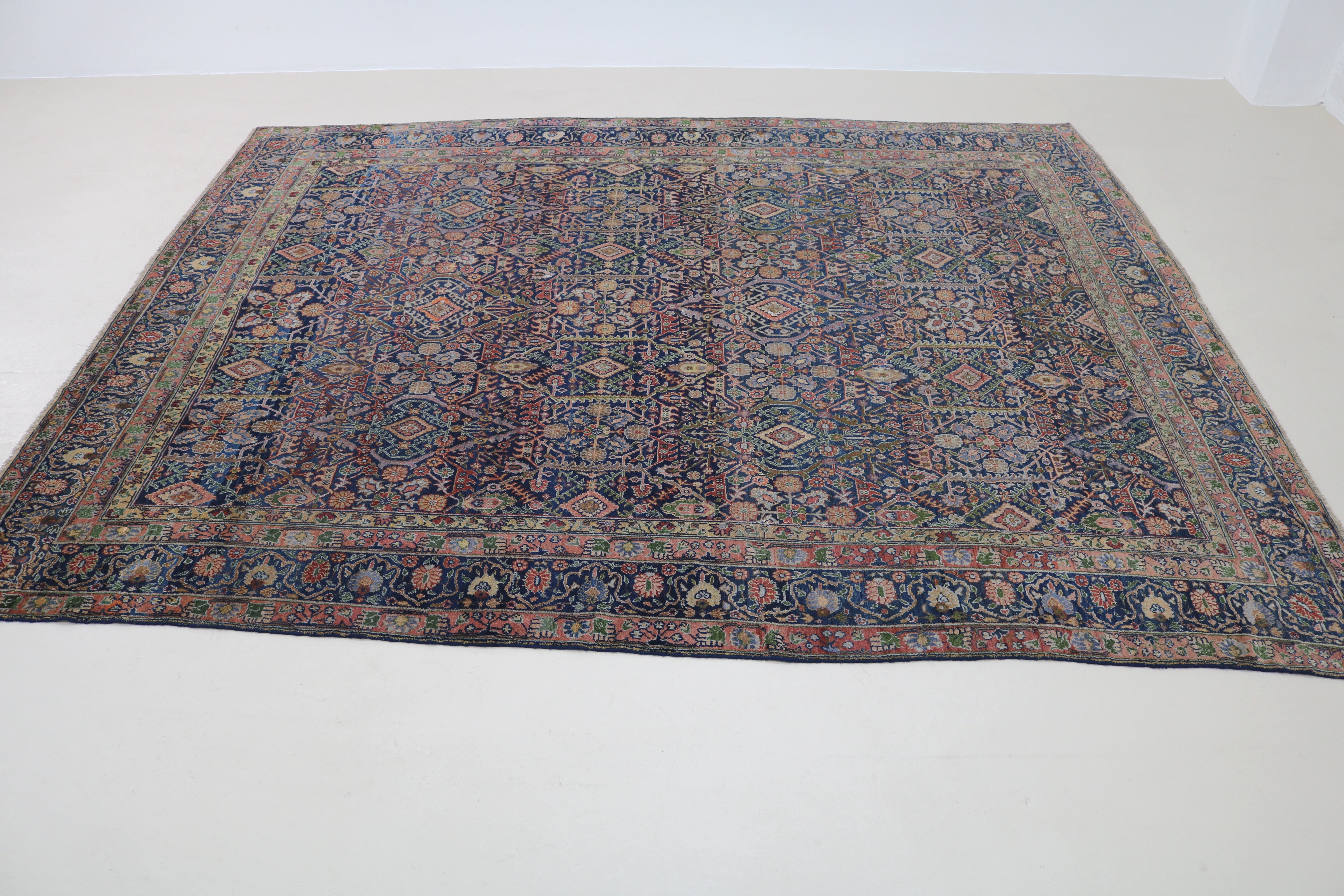 Perspective view of antique Persian Senneh carpet on floor
