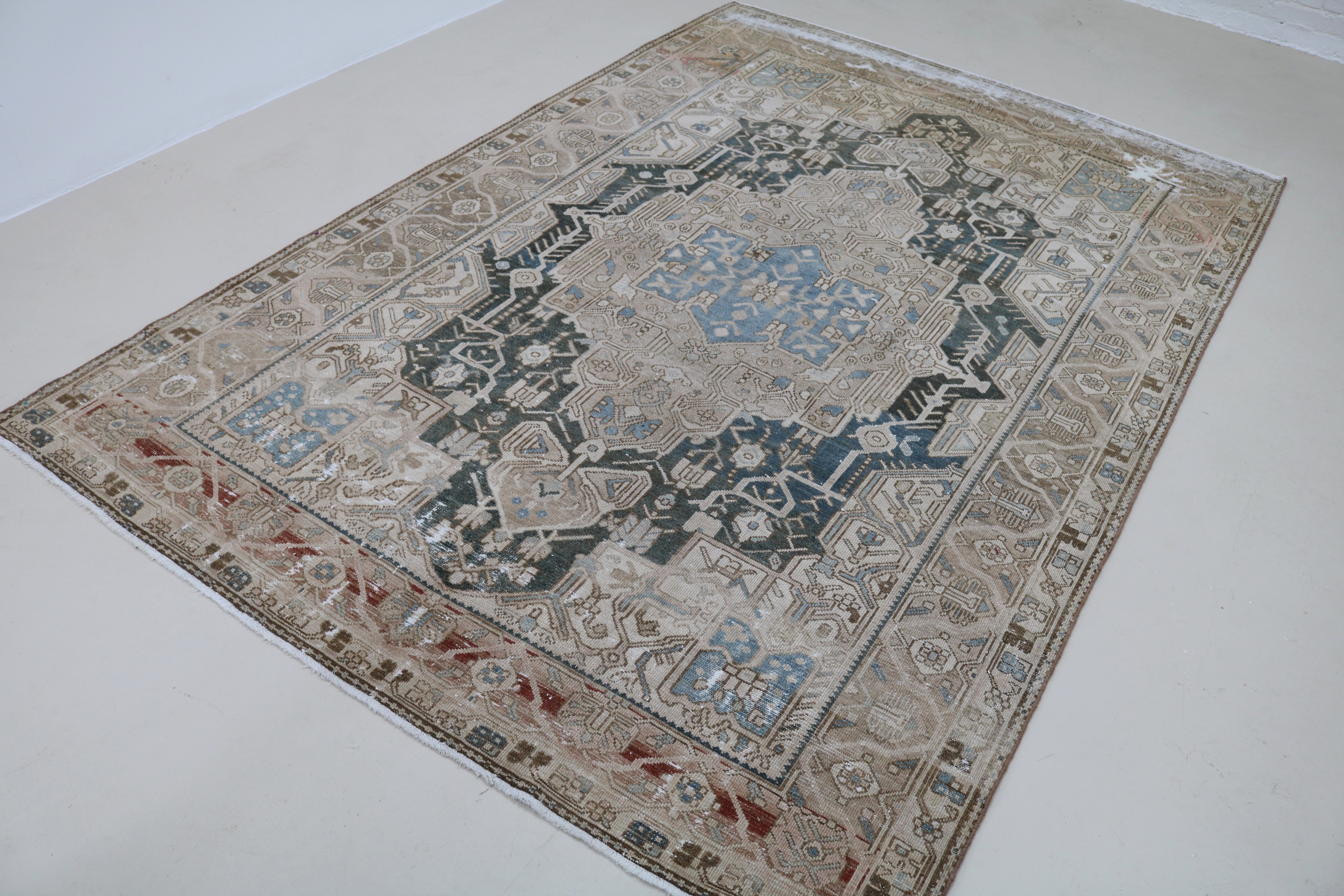 Angled view of antique Persian Karaja carpet showing field and border details