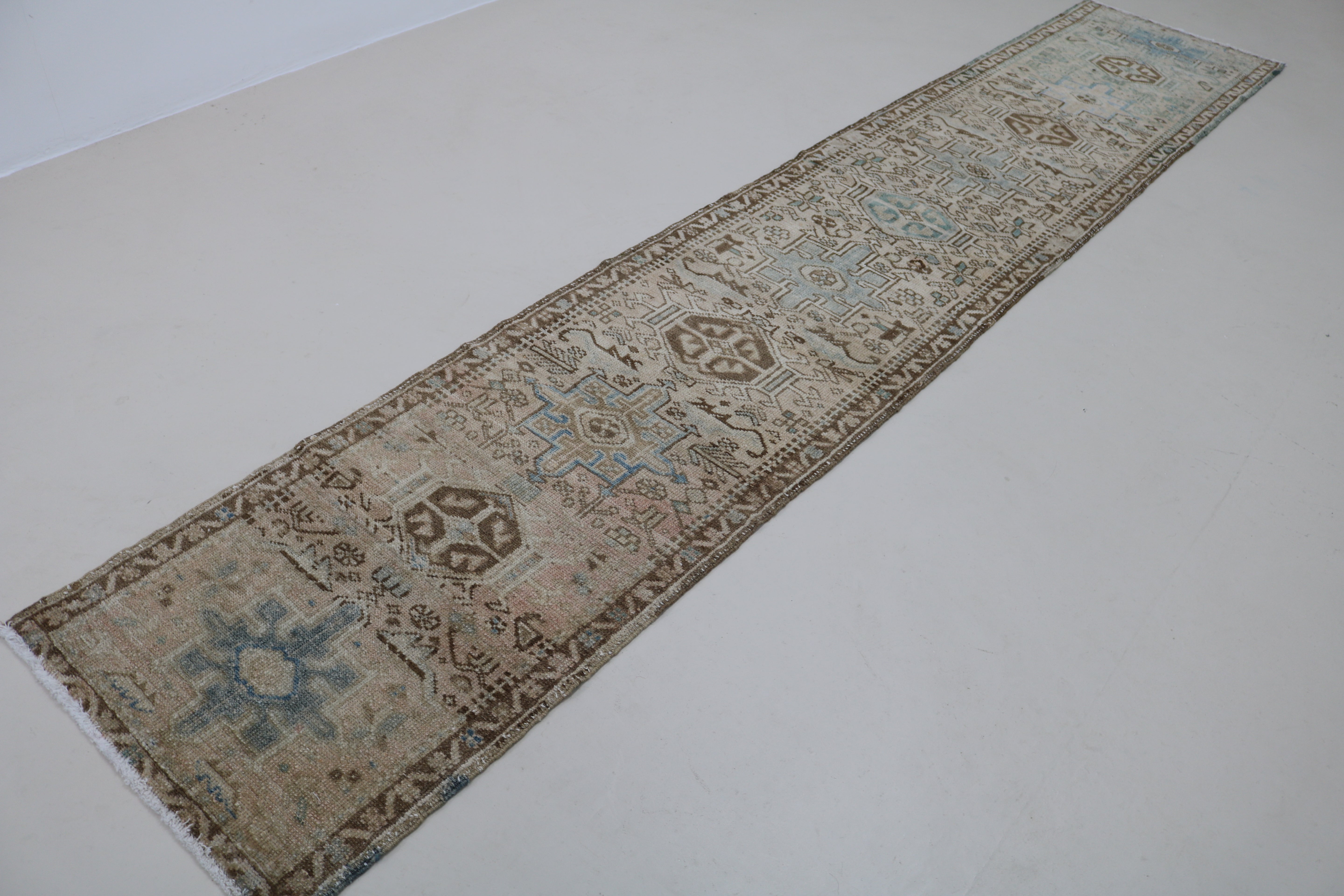 Angled view of antique Persian Heriz runner showing field and borders