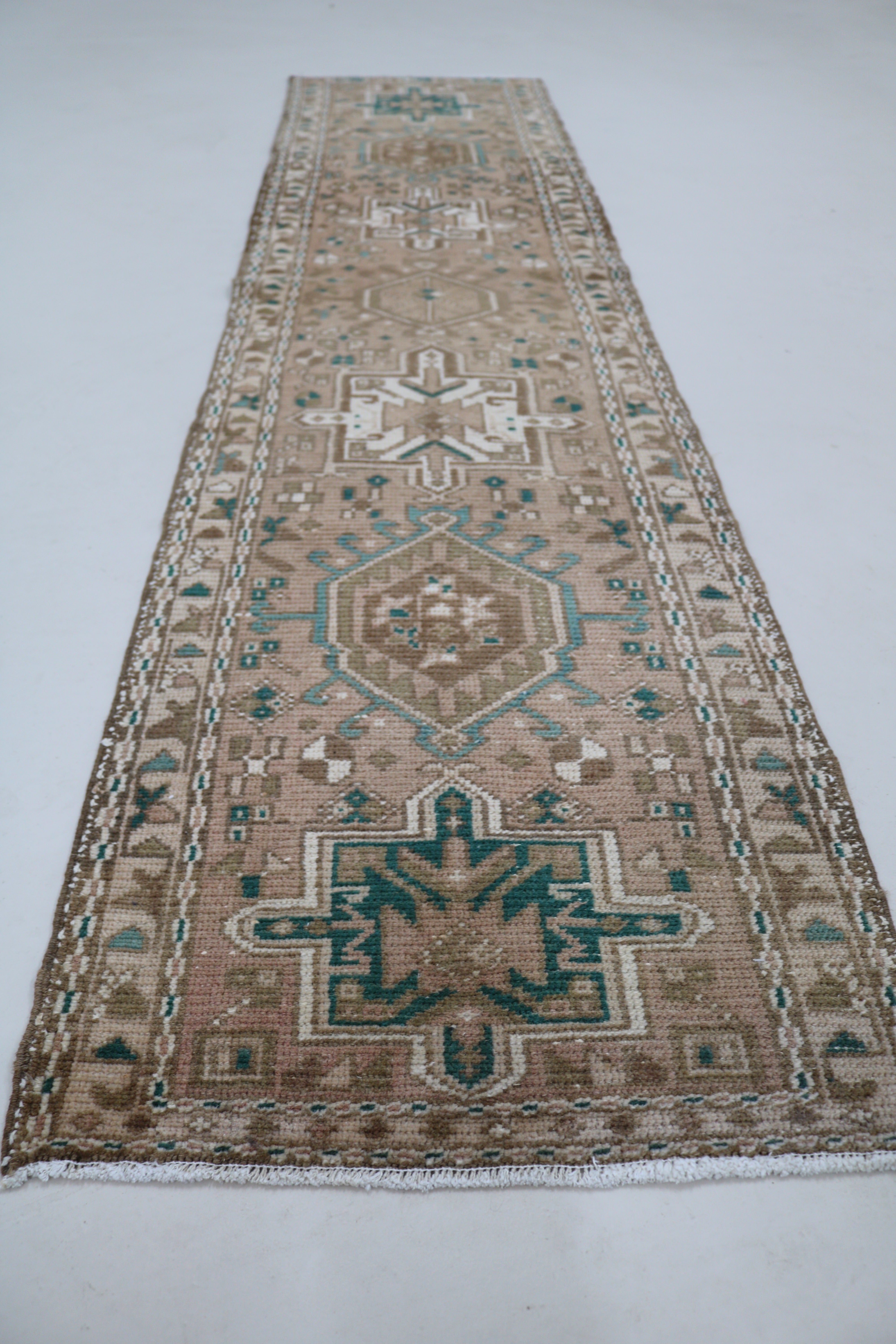 Angled view of antique Persian Heriz runner showing field and borders