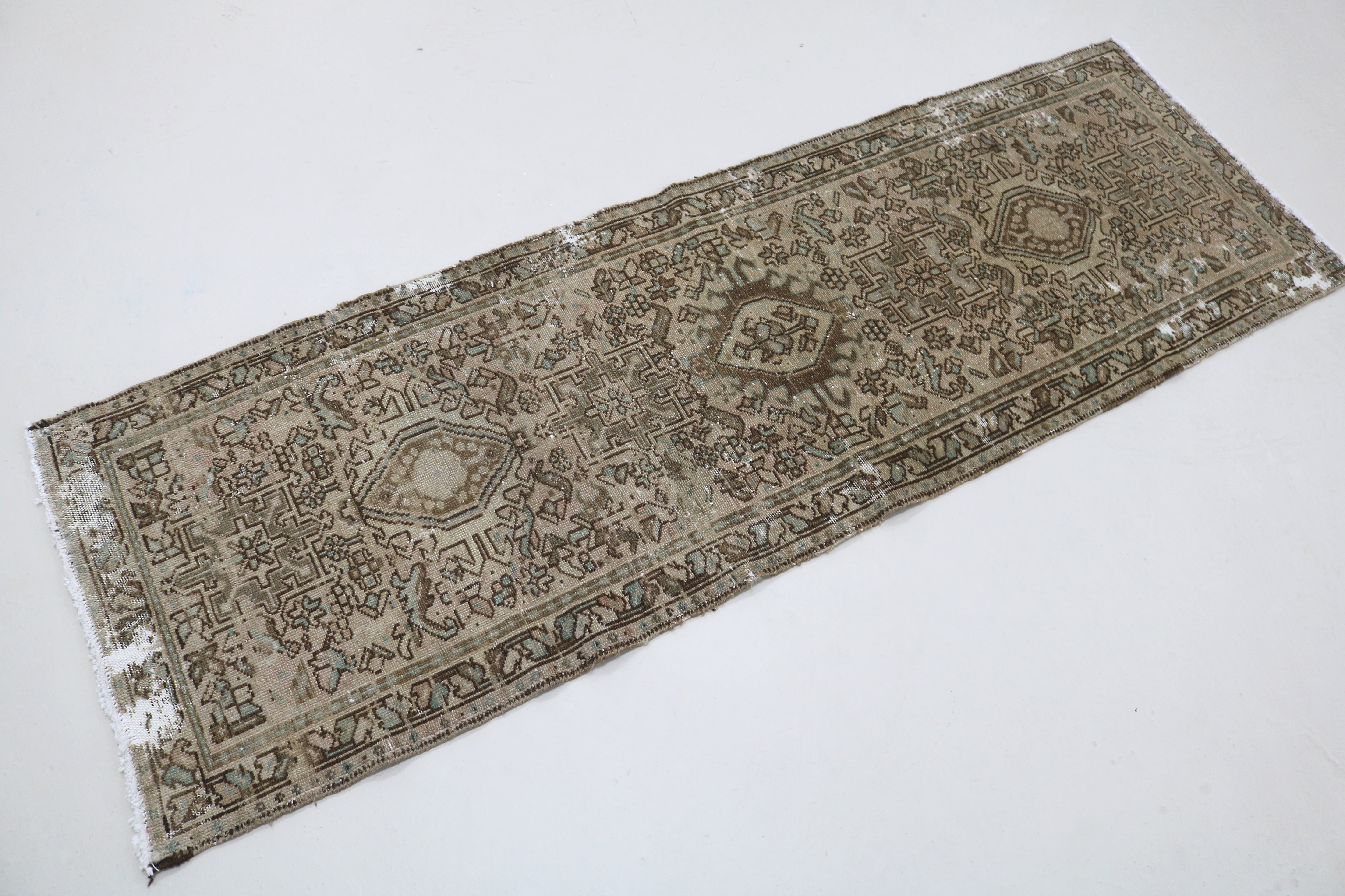 Angled view of antique Persian Heriz runner showing field and borders