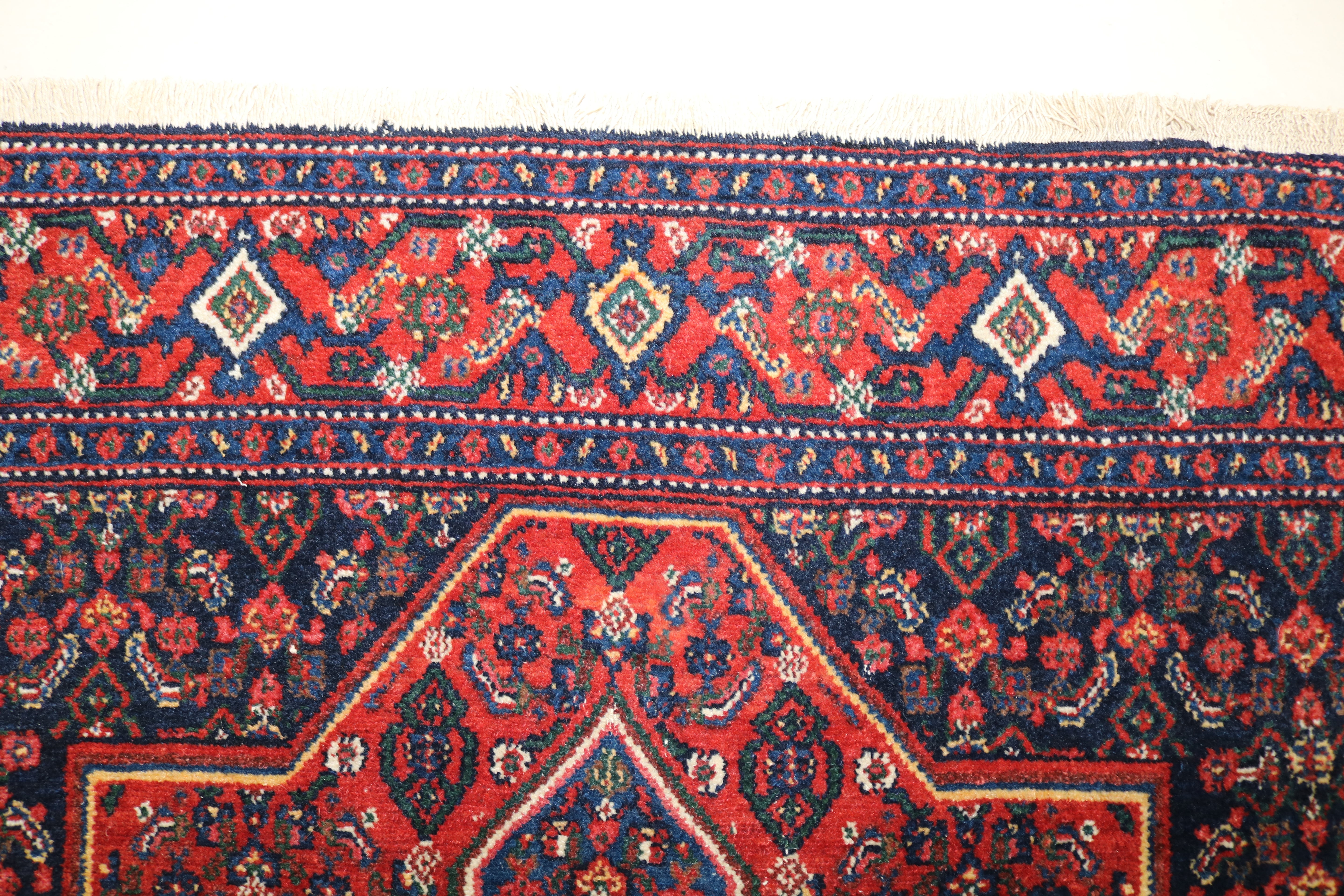 Close-up of hand-knotted wool texture on antique Persian Senneh rug