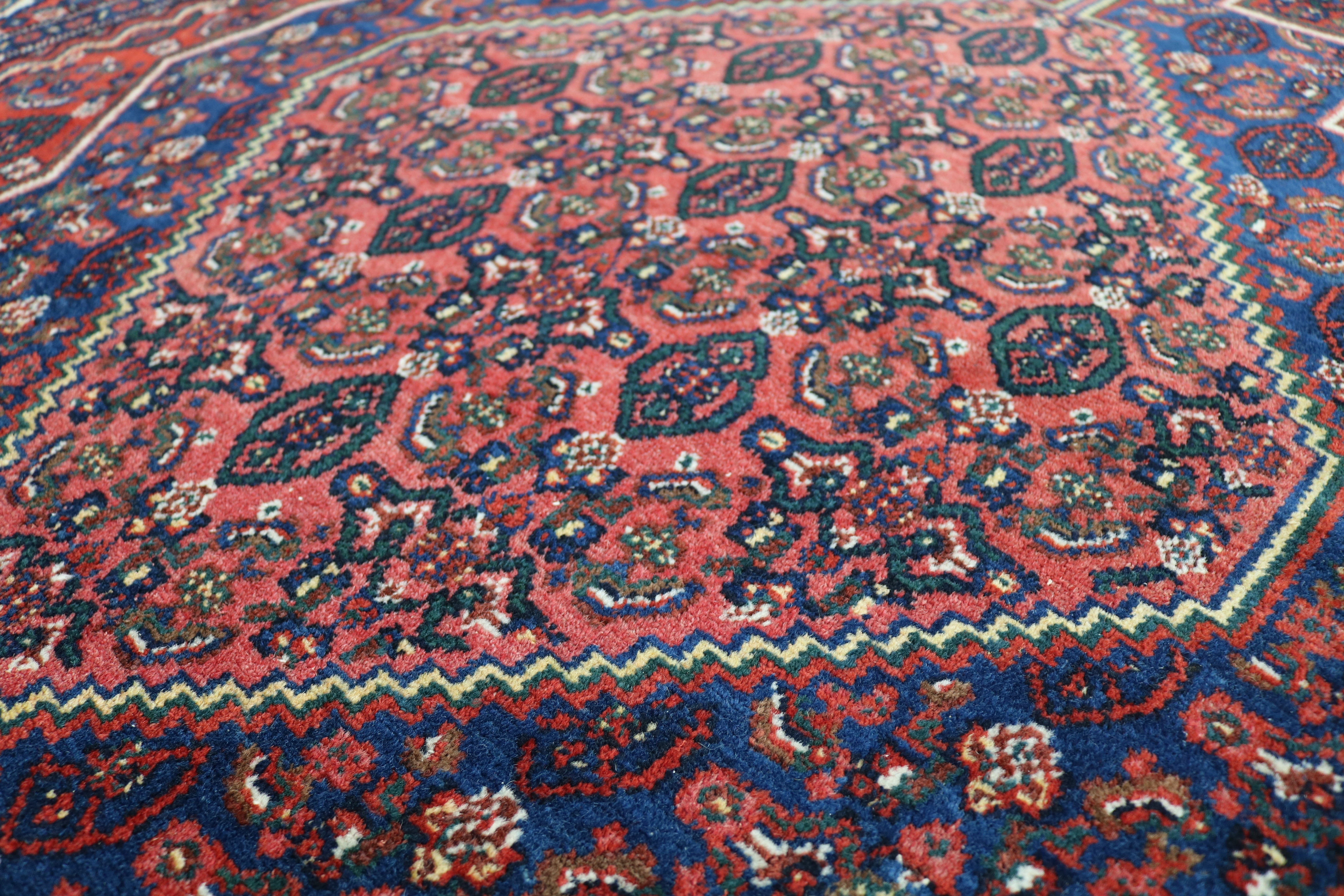 Close-up of hand-knotted wool texture on antique Persian Senneh rug