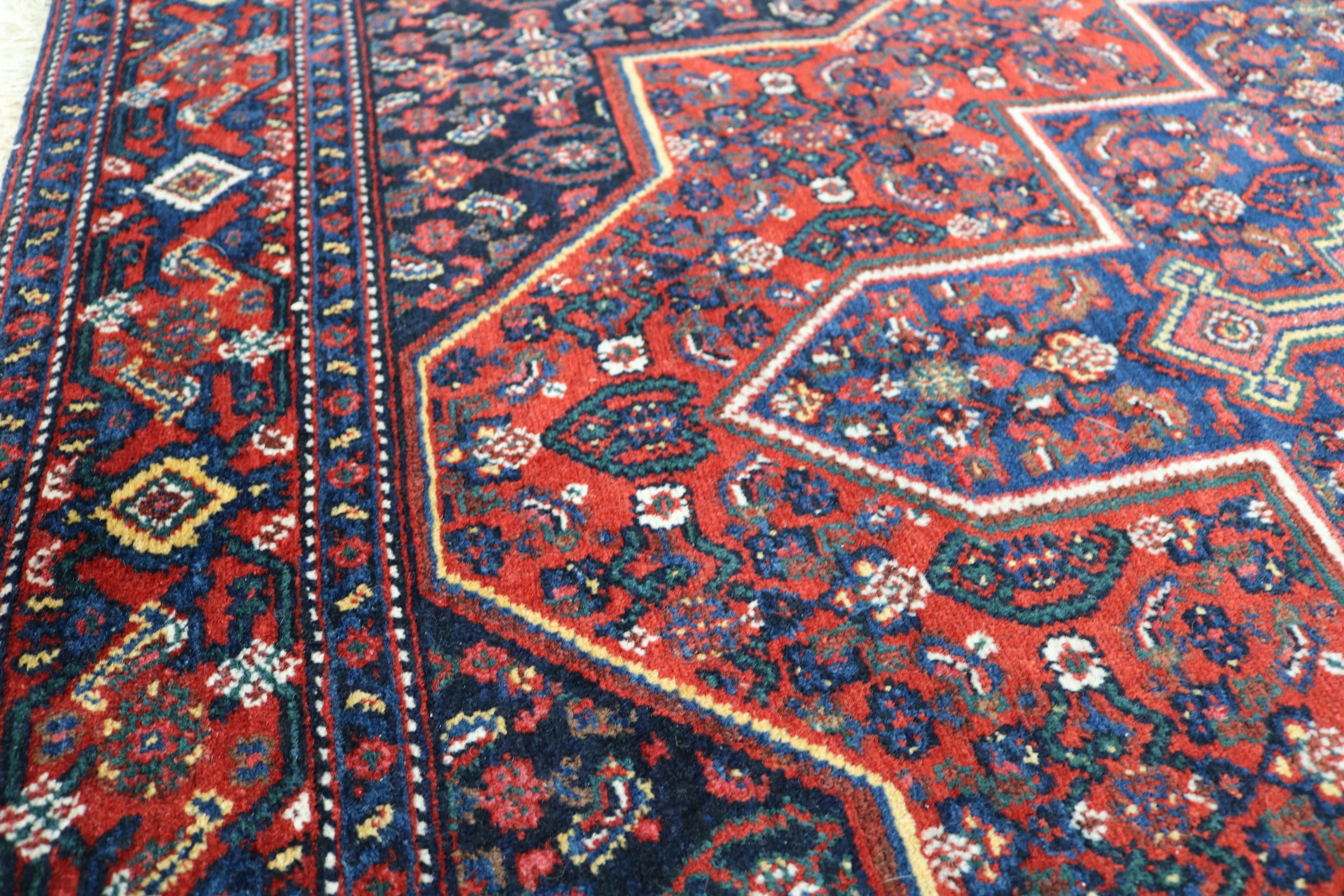 Close-up of hand-knotted wool texture on antique Persian Senneh rug