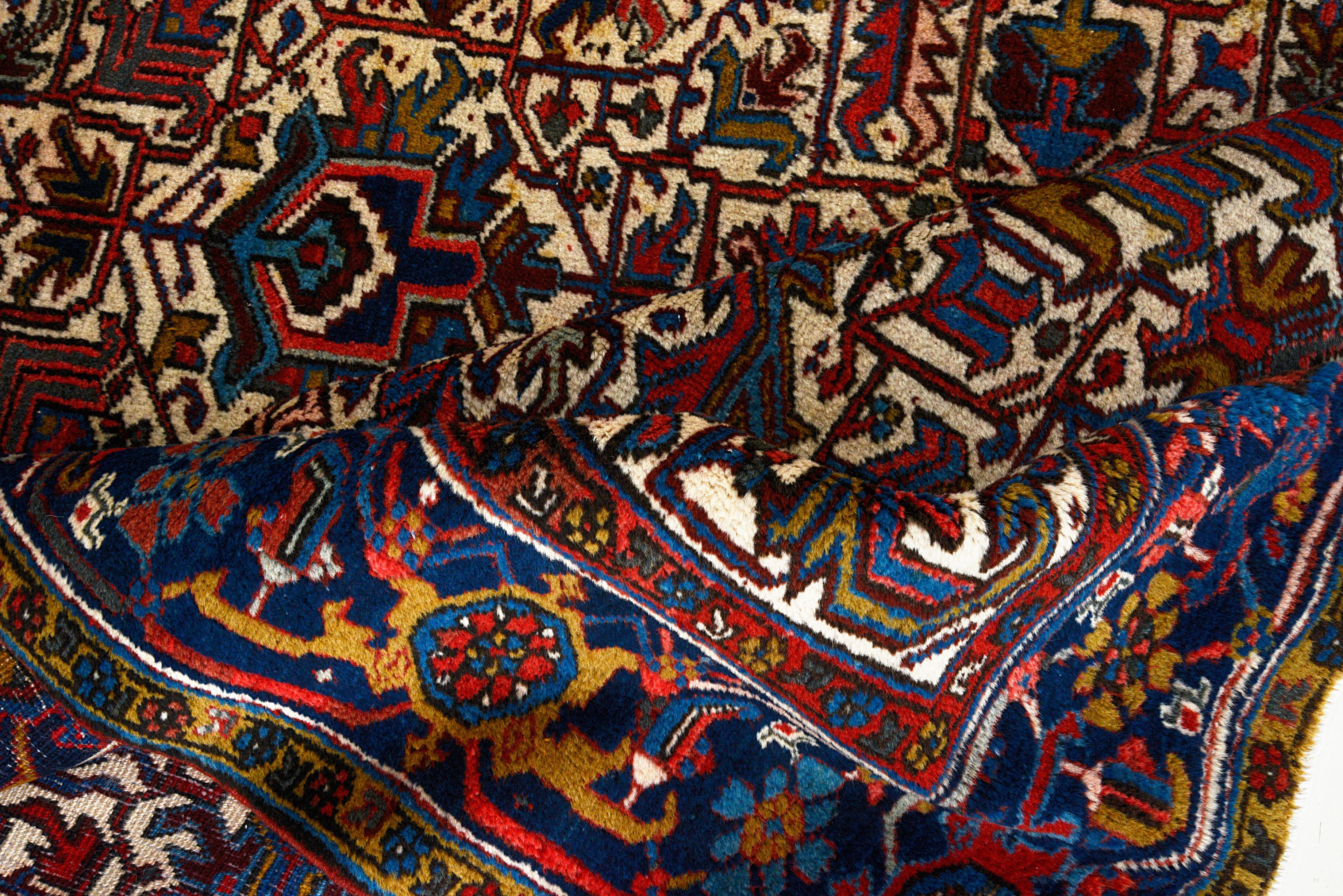 Close-up details of vintage Heriz carpet showing wool texture, motifs, and natural patina