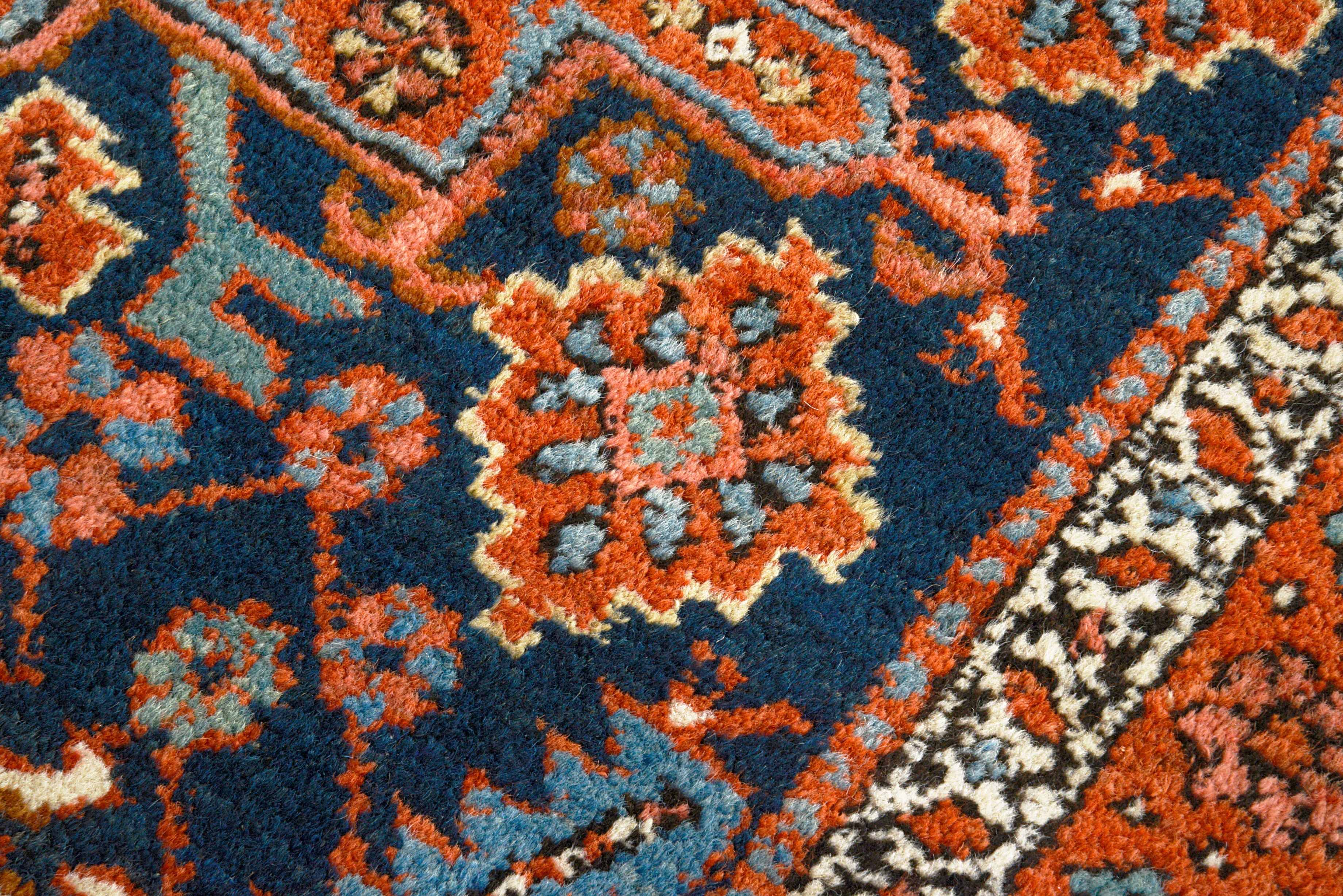 Close-up details of antique Persian Heriz rug showing wool texture, motifs, and natural ageing