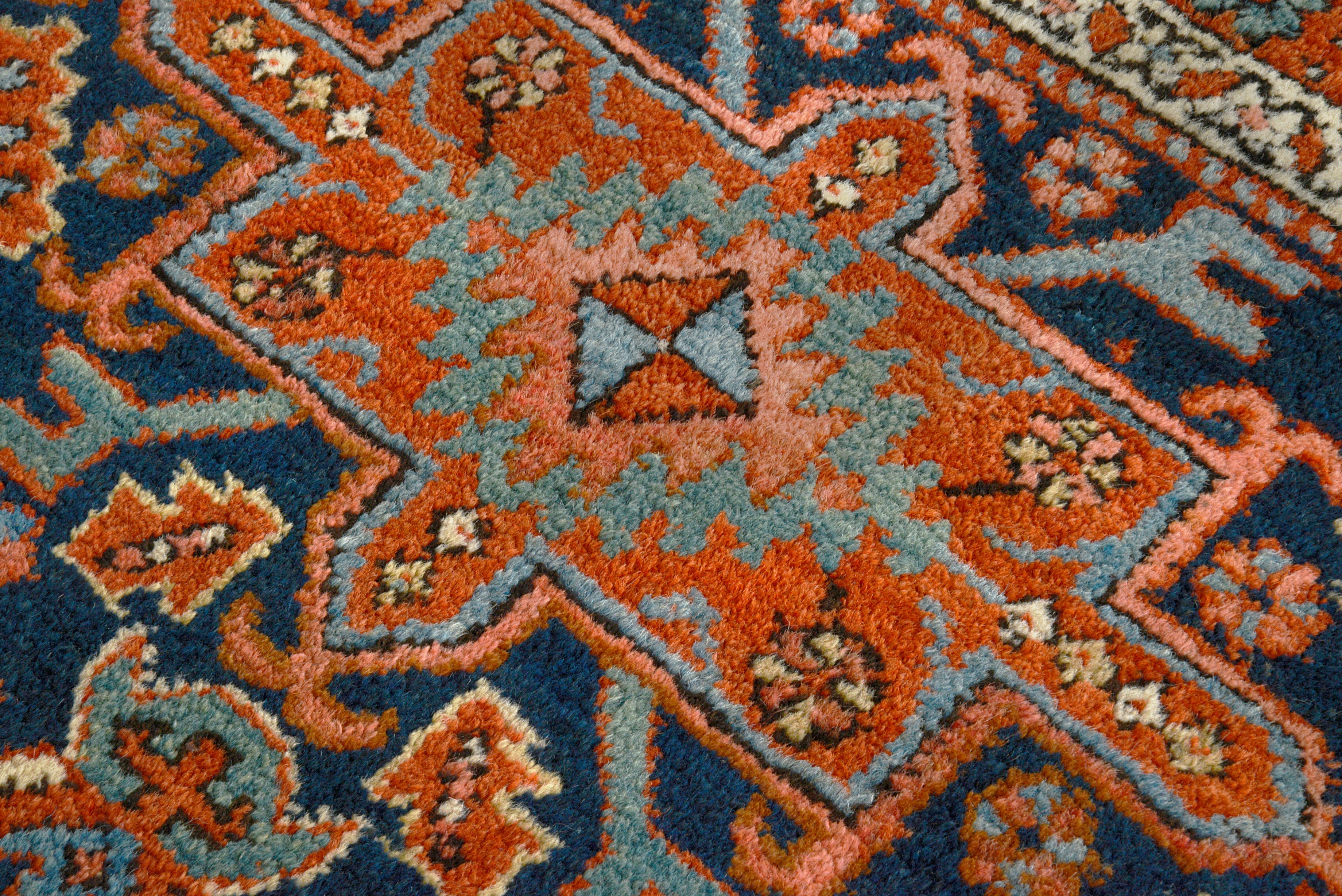 Close-up details of antique Persian Heriz rug showing wool texture, motifs, and natural ageing