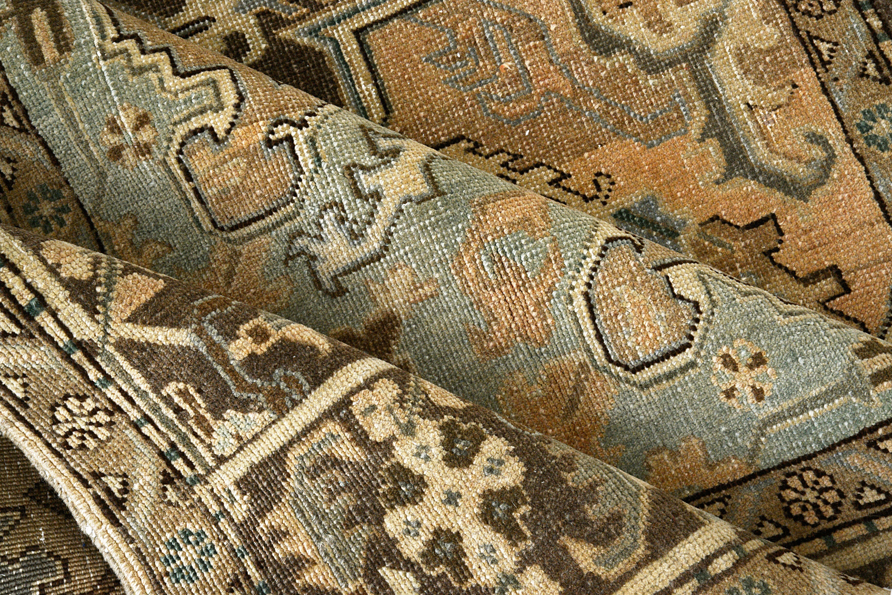 Close-up details of vintage Persian Heriz rug showing wool texture, motifs, and natural patina