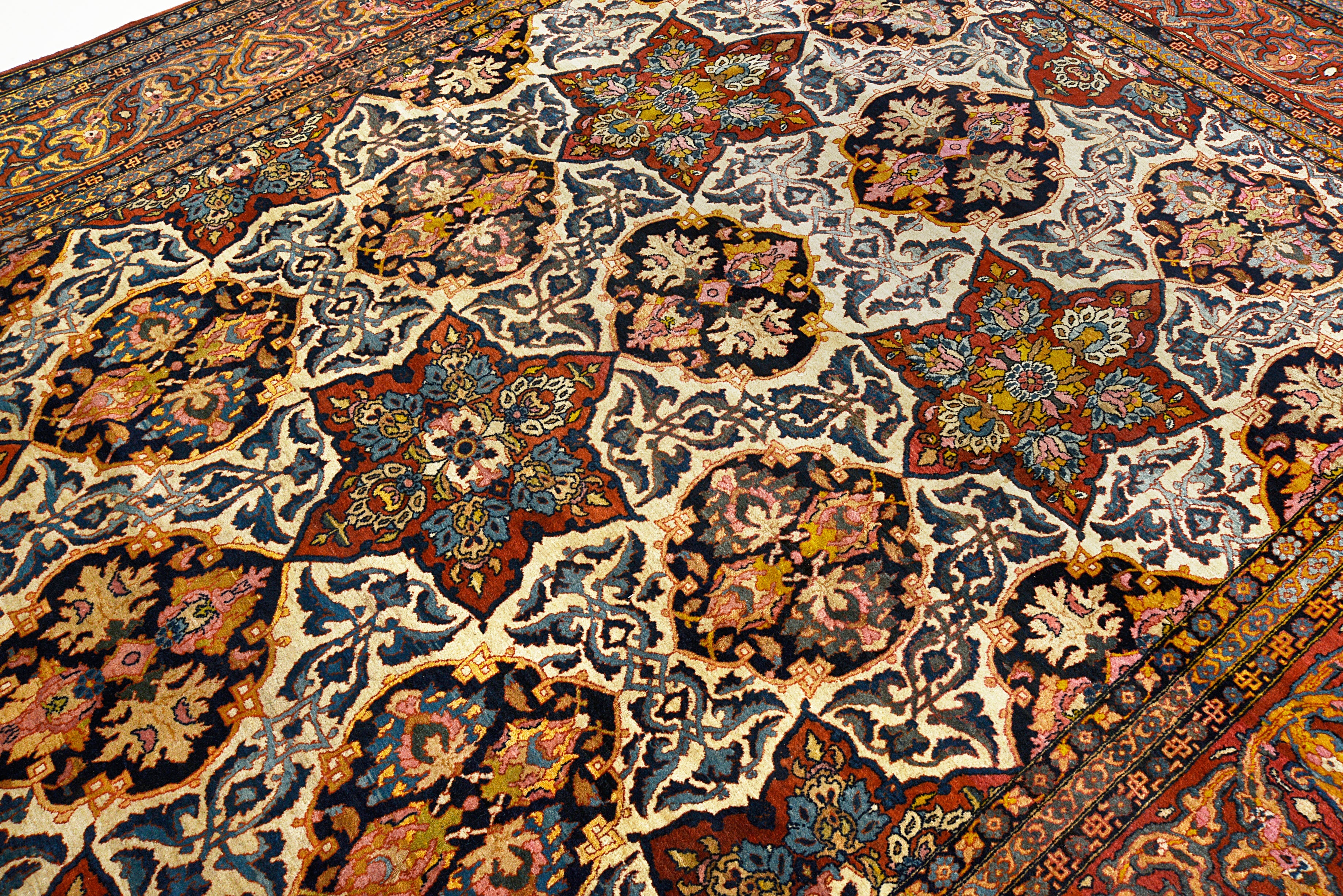 Close-up details of fine antique Isfahan carpet showing wool texture, floral motifs, and aged patina