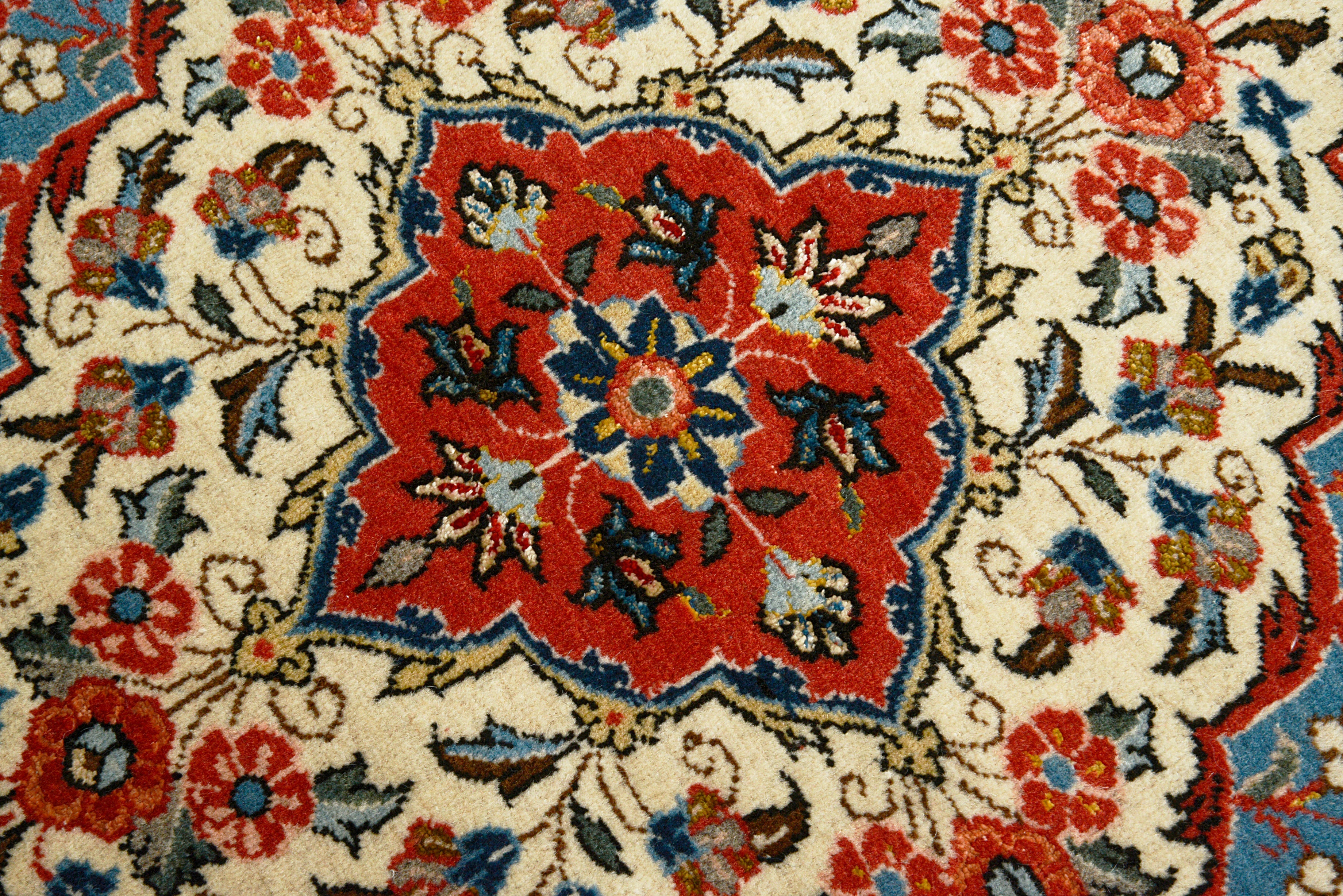 Close-up details of fine antique Persian Qom rug showing wool texture, floral motifs, and aged patina