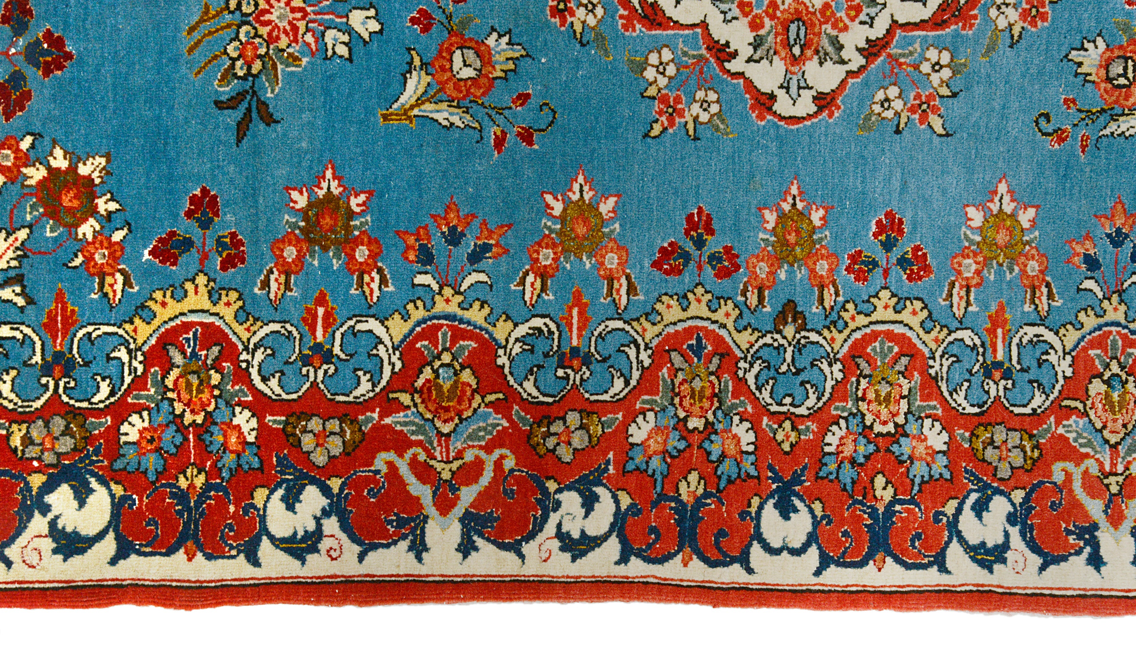 Close-up details of fine antique Persian Qom rug showing wool texture, floral motifs, and aged patina