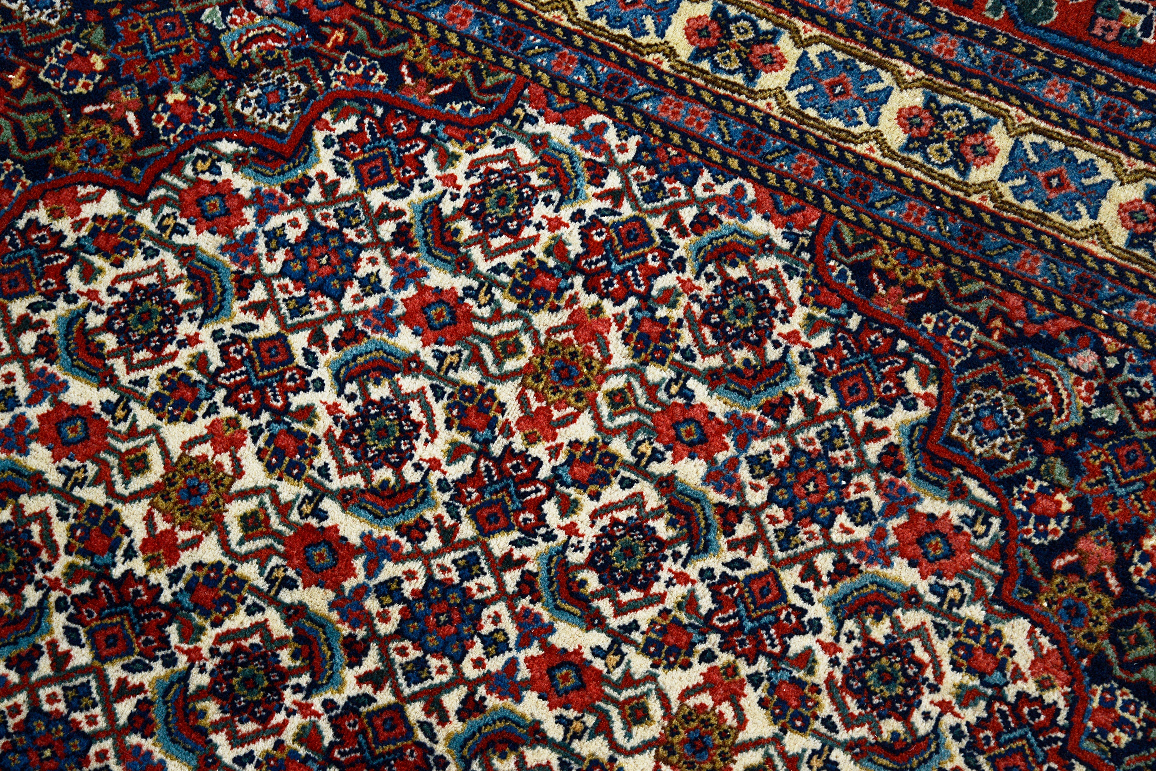 Close-up details of vintage Persian Tabriz carpet showing fine wool texture, motifs, and natural patina