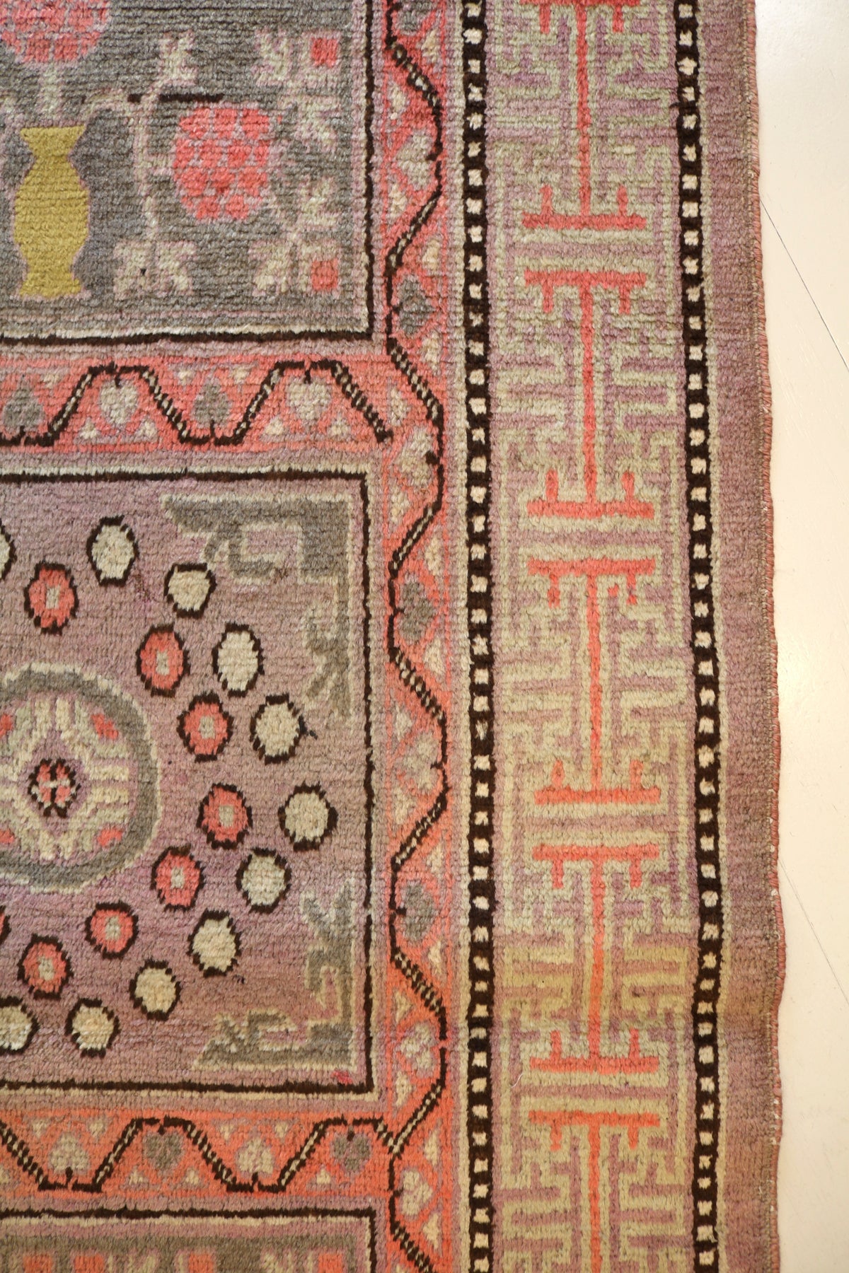 Close-up of rug edge with structured floral and geometric panels