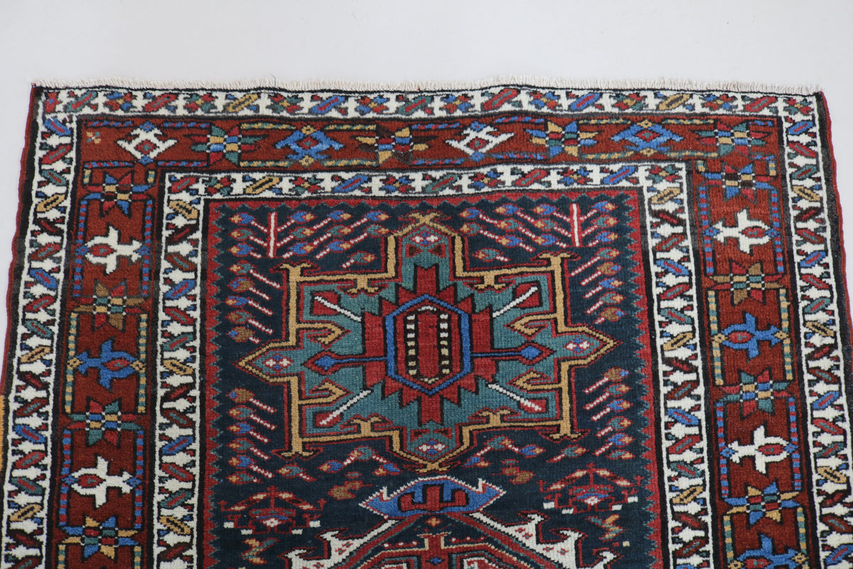 Full Heriz runner showing geometric medallions framed by detailed tribal borders