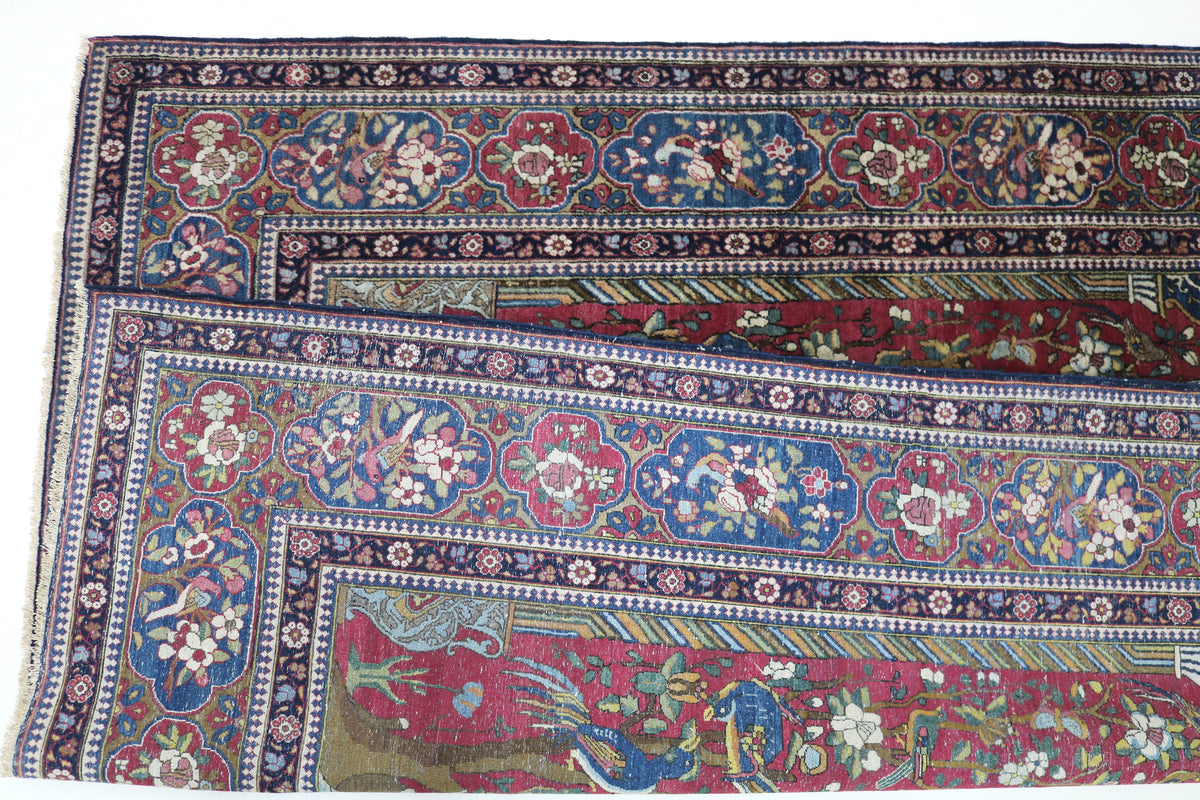 Close-up of antique Isfahan rug showing central floral design and decorative border