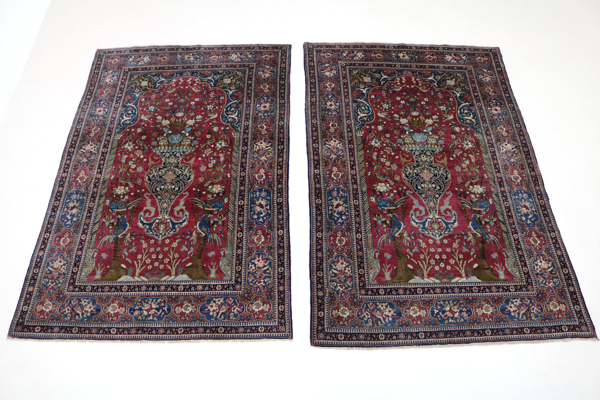 Two antique Isfahan rugs displayed together with richly detailed floral designs and borders