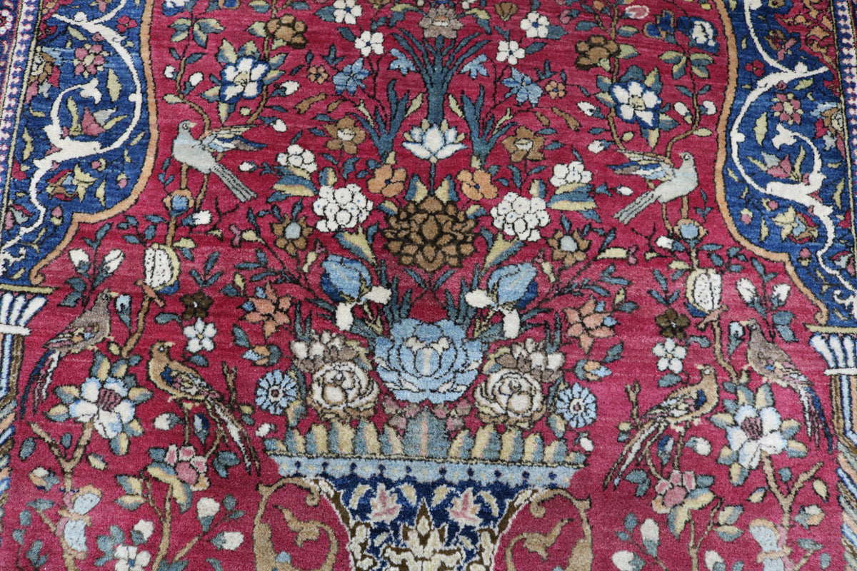Detailed antique Isfahan rug with dense floral design across a deep red field
