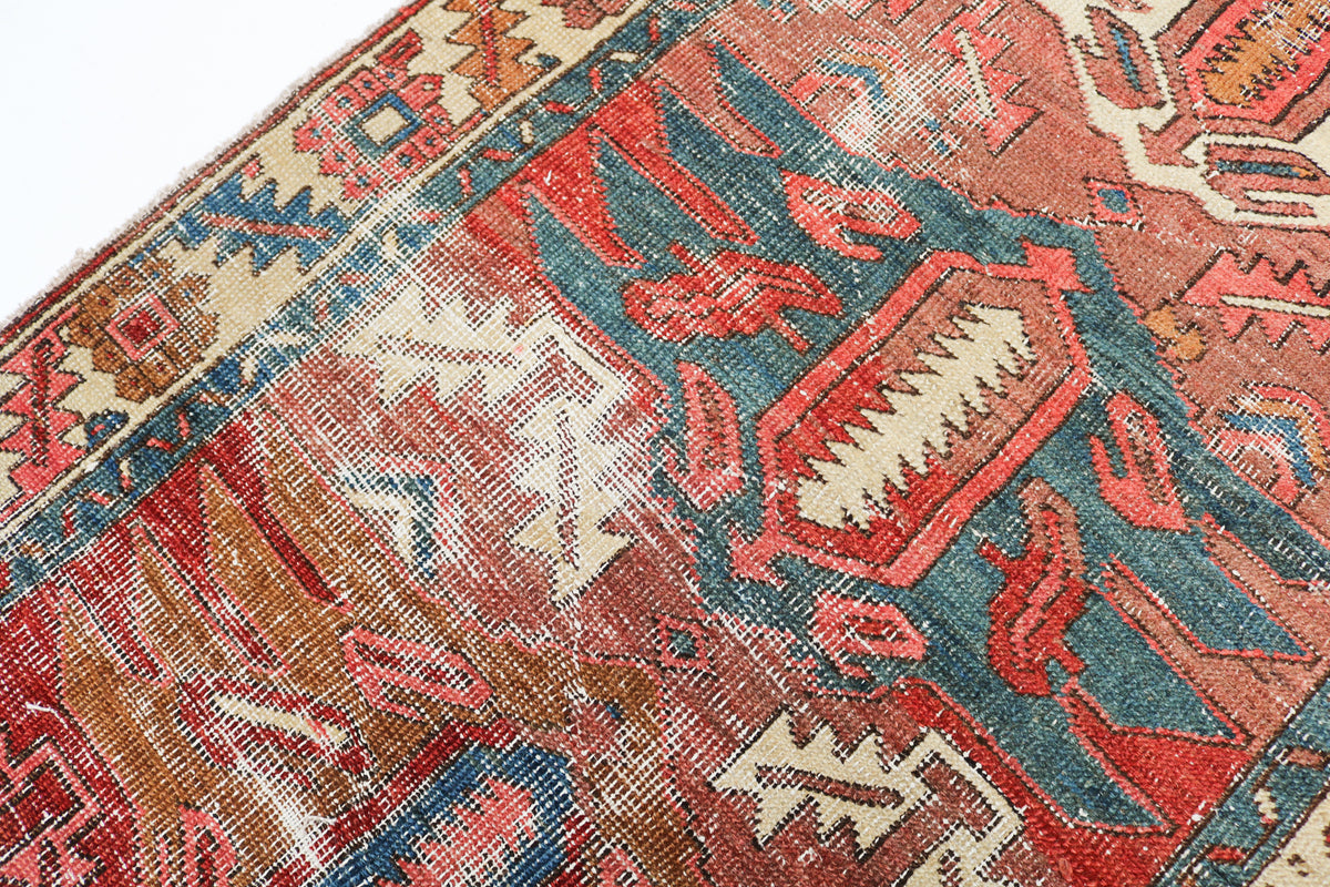 Detailed view of an antique Persian runner rug with geometric motifs and traditional red and blue pattern