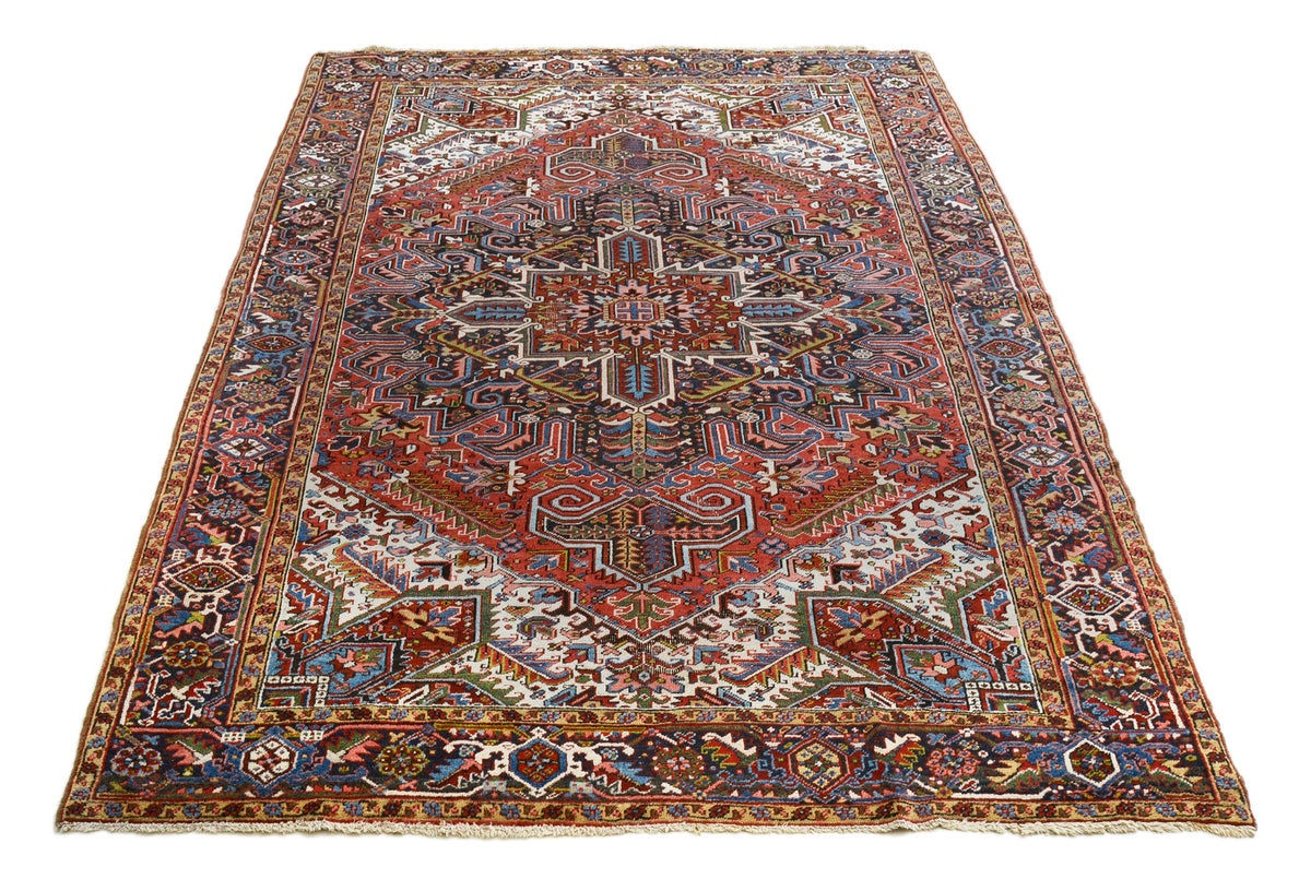 Full view of antique Persian Heriz carpet with geometric medallion and richly patterned borders