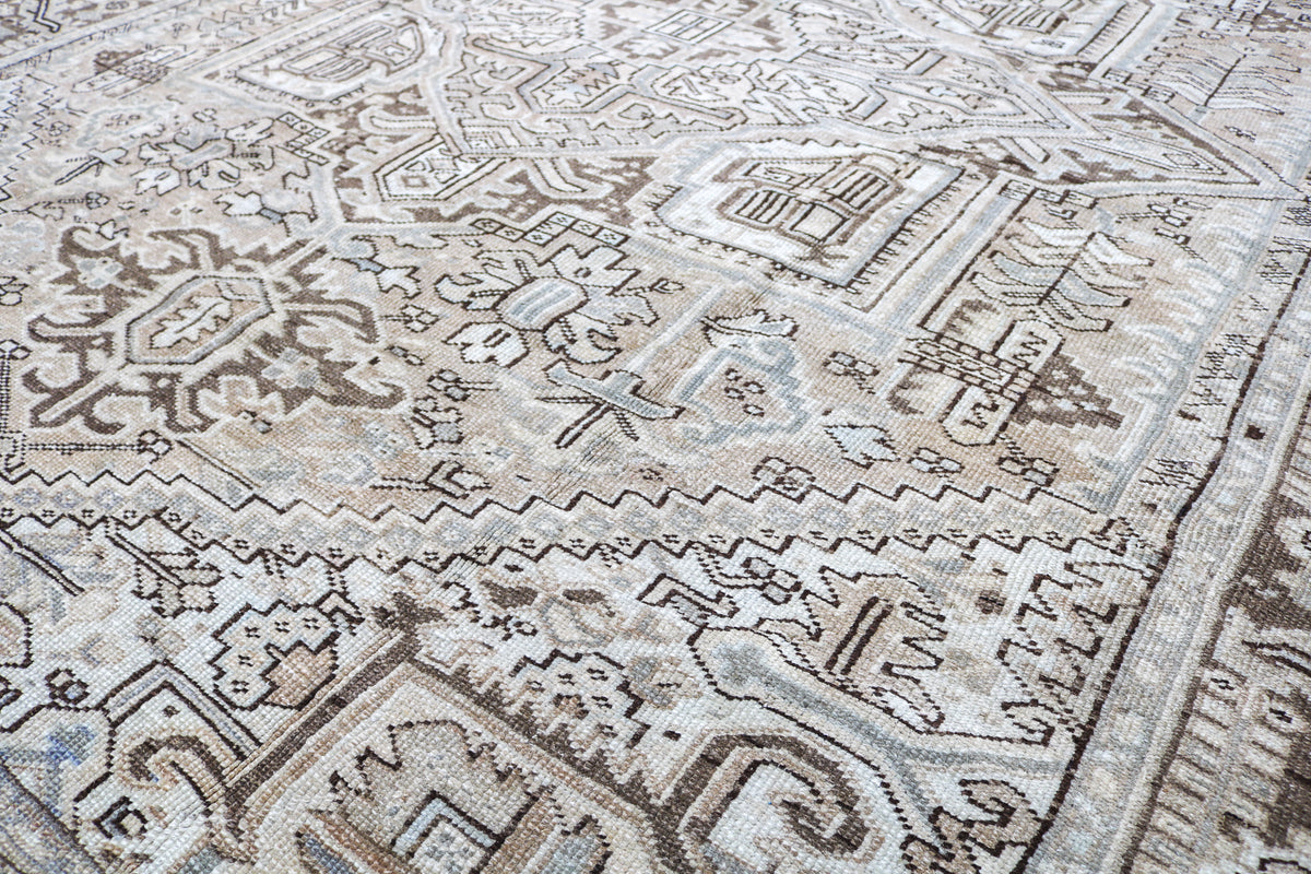 Close-up of Heriz carpet showing detailed geometric patterns in ivory and muted brown