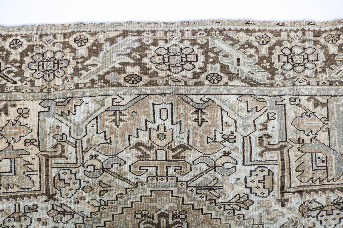 Detailed Heriz carpet field showing ivory, beige and faded blue geometric patterns