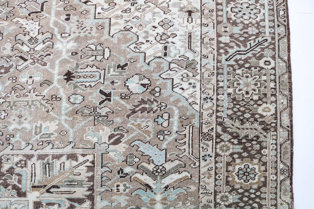 Detailed Persian Heriz carpet border featuring floral and geometric patterns in muted colours