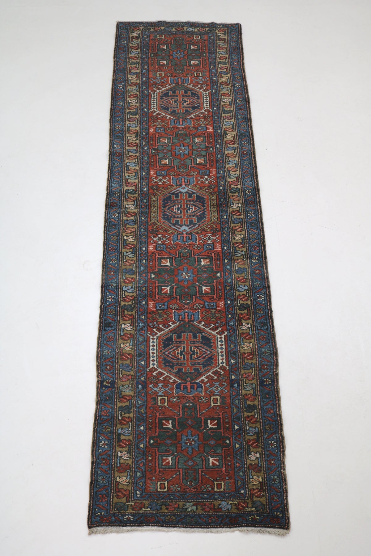 Full view of antique Karaja runner with single-column medallion design and narrow elongated format