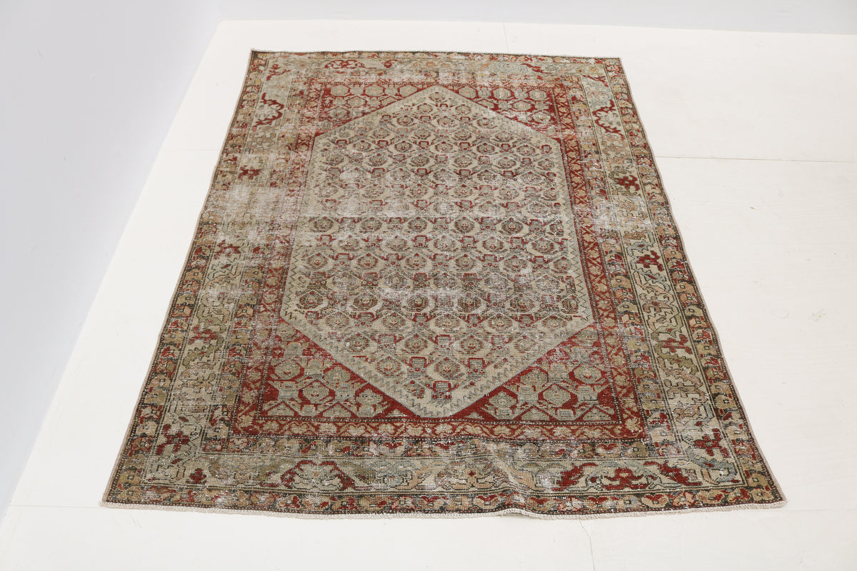 Close-up of antique Persian Malayer rug showing naturally worn wool pile and faded geometric motifs