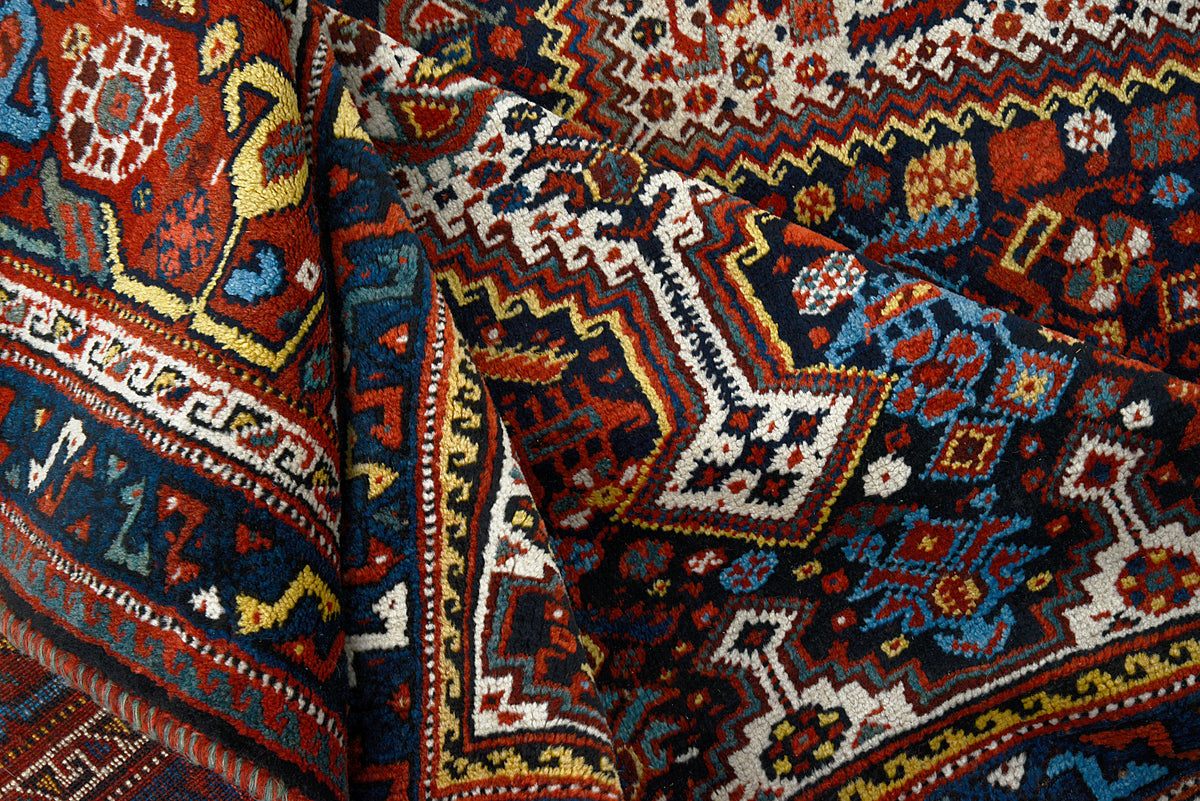 Detailed view of Qashqai carpet showing intricate diamond motifs and rich madder red tones