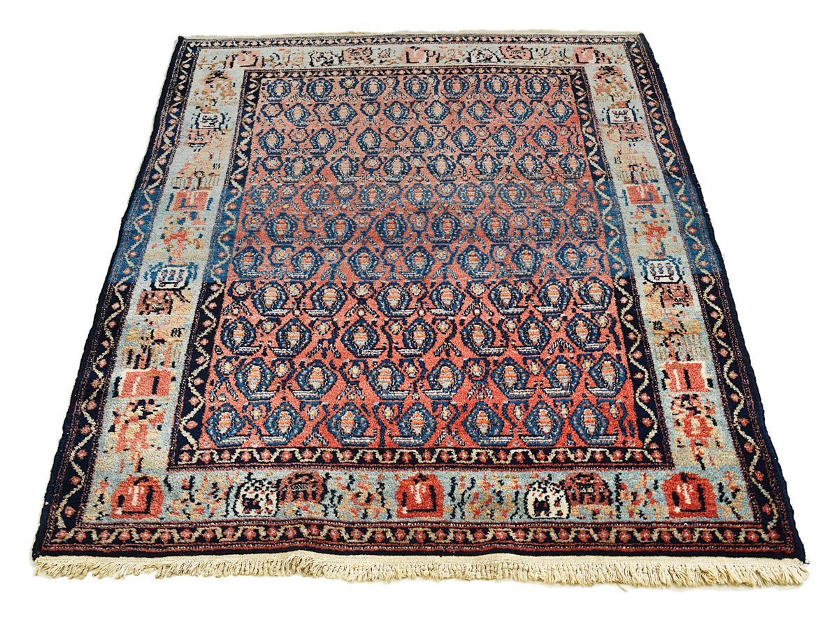 Full view of antique Senneh rug with dense boteh pattern in coral, indigo and ivory