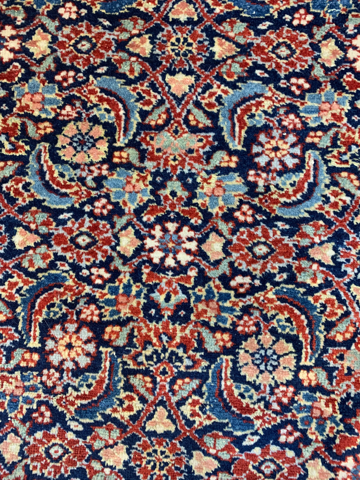 Close-up of intricate all-over floral pattern in blue, red and ivory tones