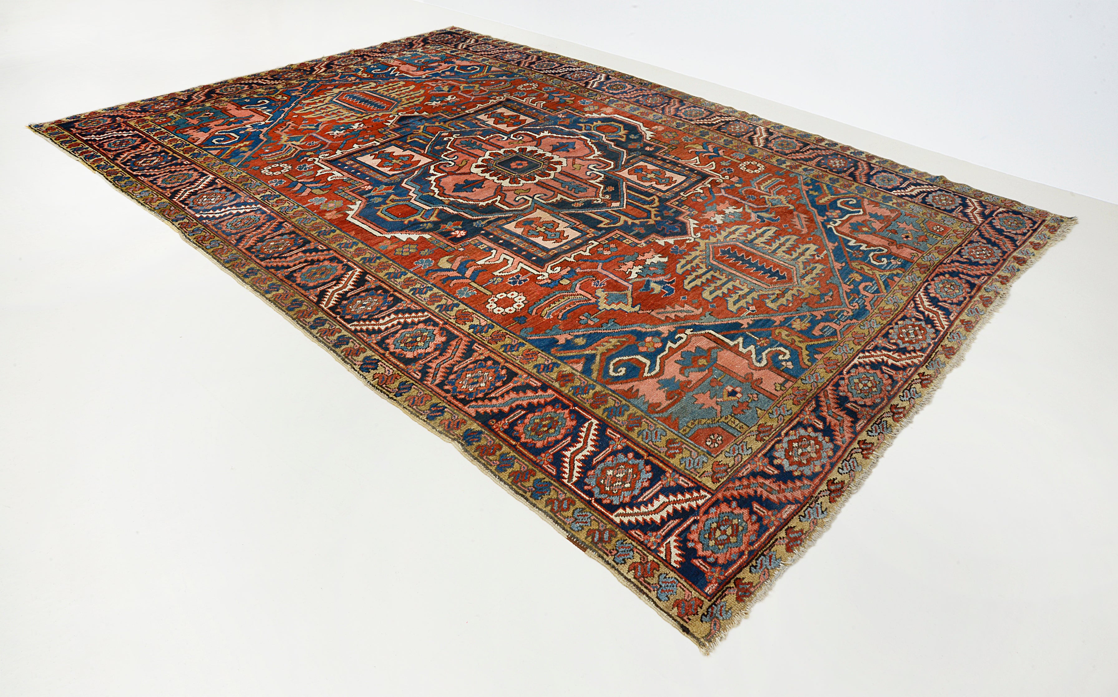 Angled view of antique Persian Heriz carpet showing field and borders