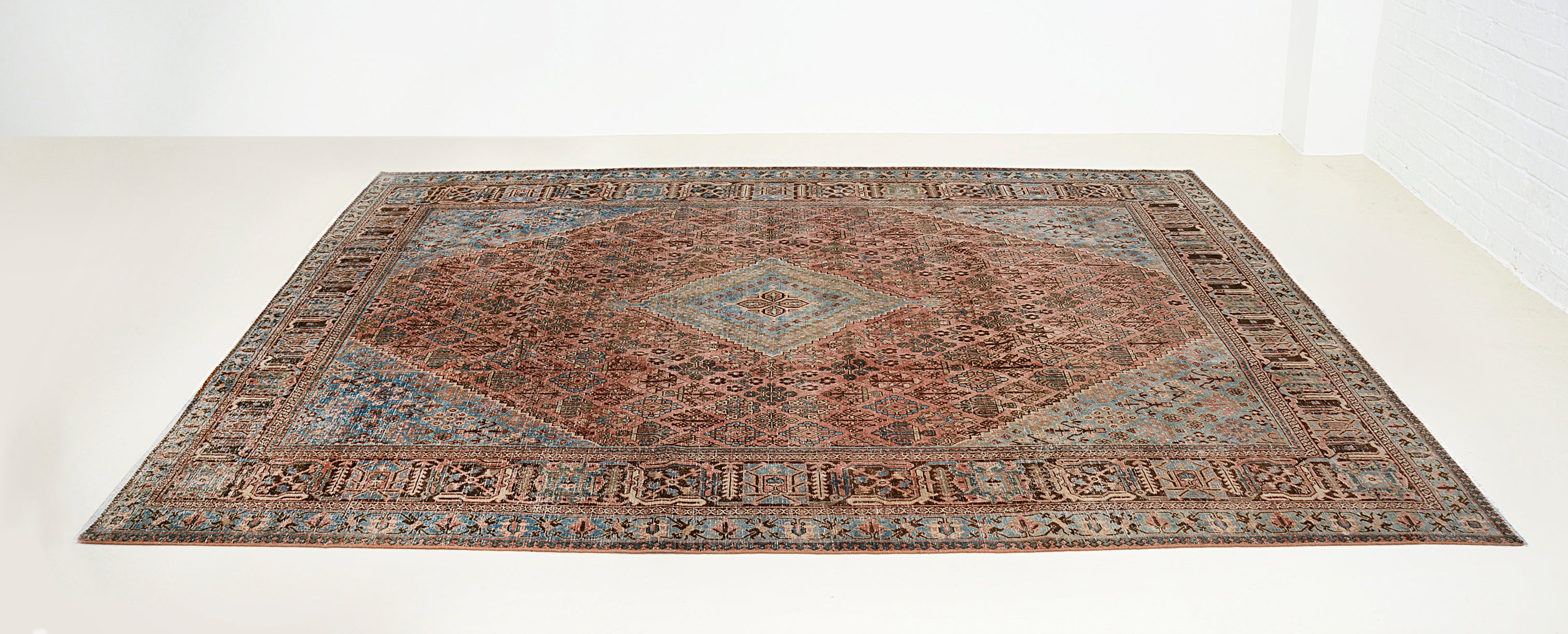 Perspective view of antique Persian Josheqan rug on floor