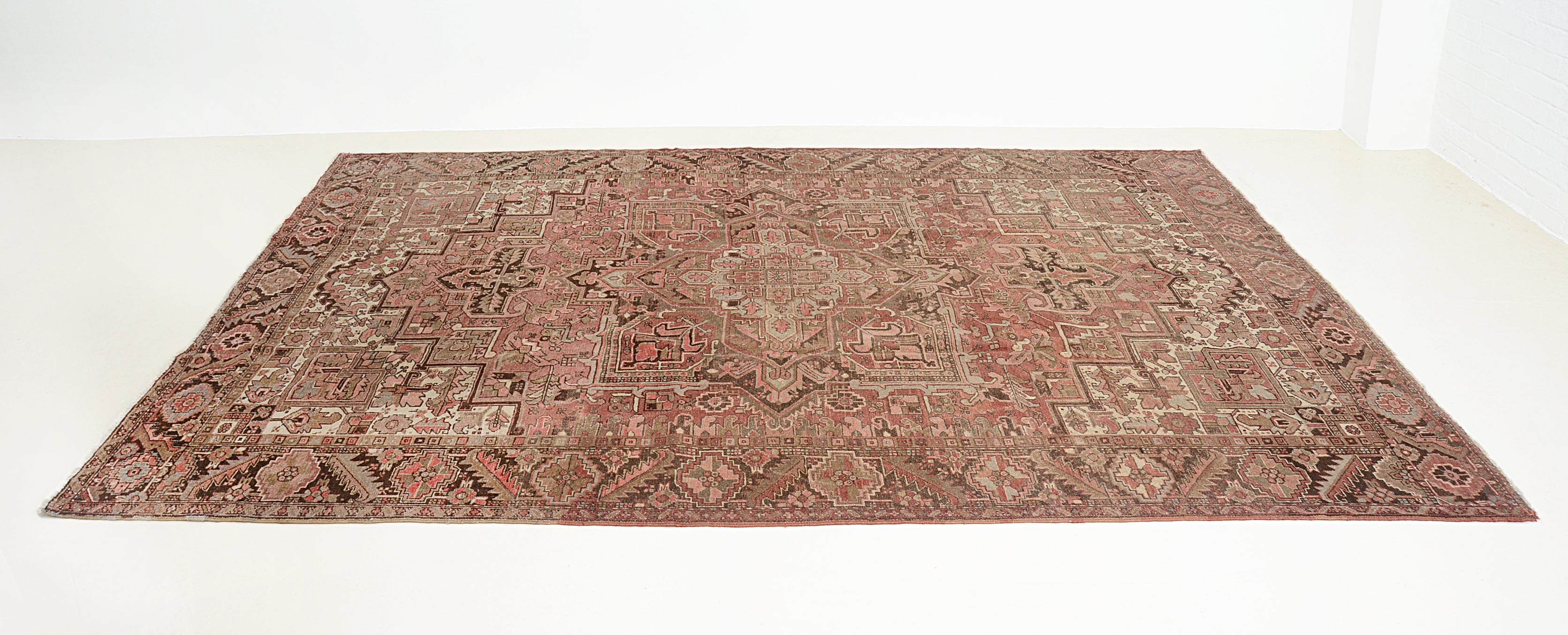 Perspective view of antique Persian Heriz carpet on floor
