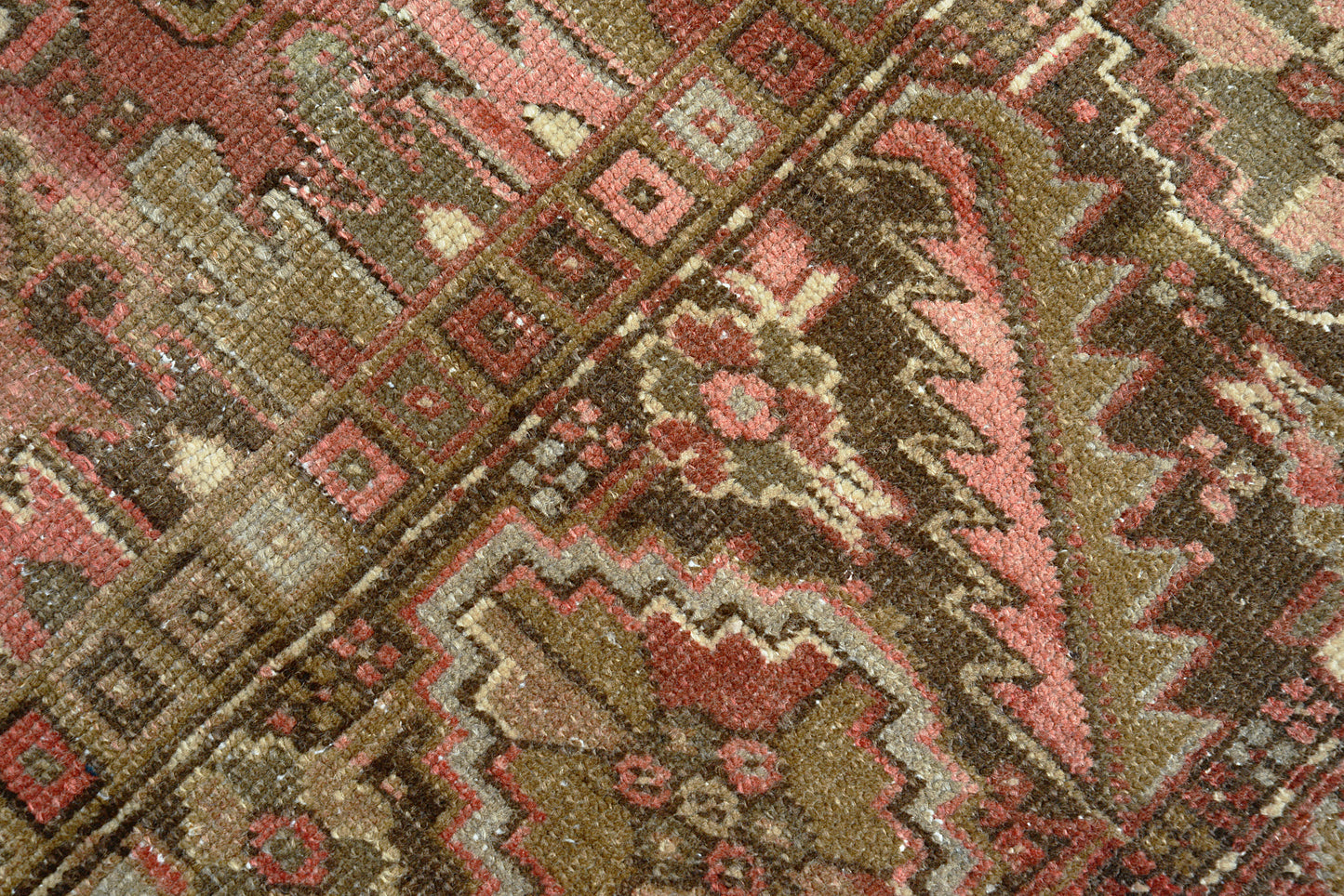 Close-up of hand-knotted wool texture on antique Persian Heriz carpet