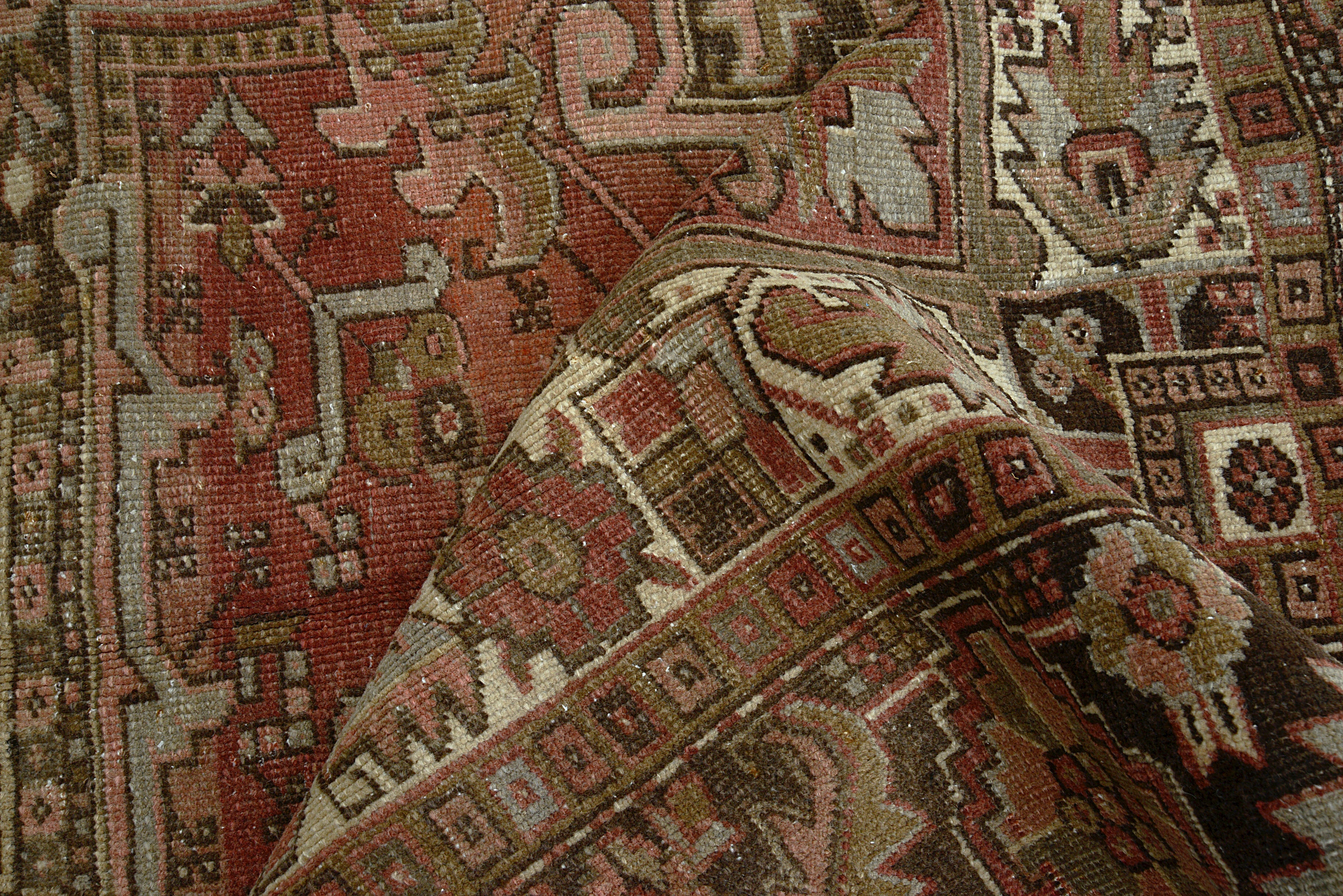 Close-up of geometric field motifs on antique Persian Heriz carpet