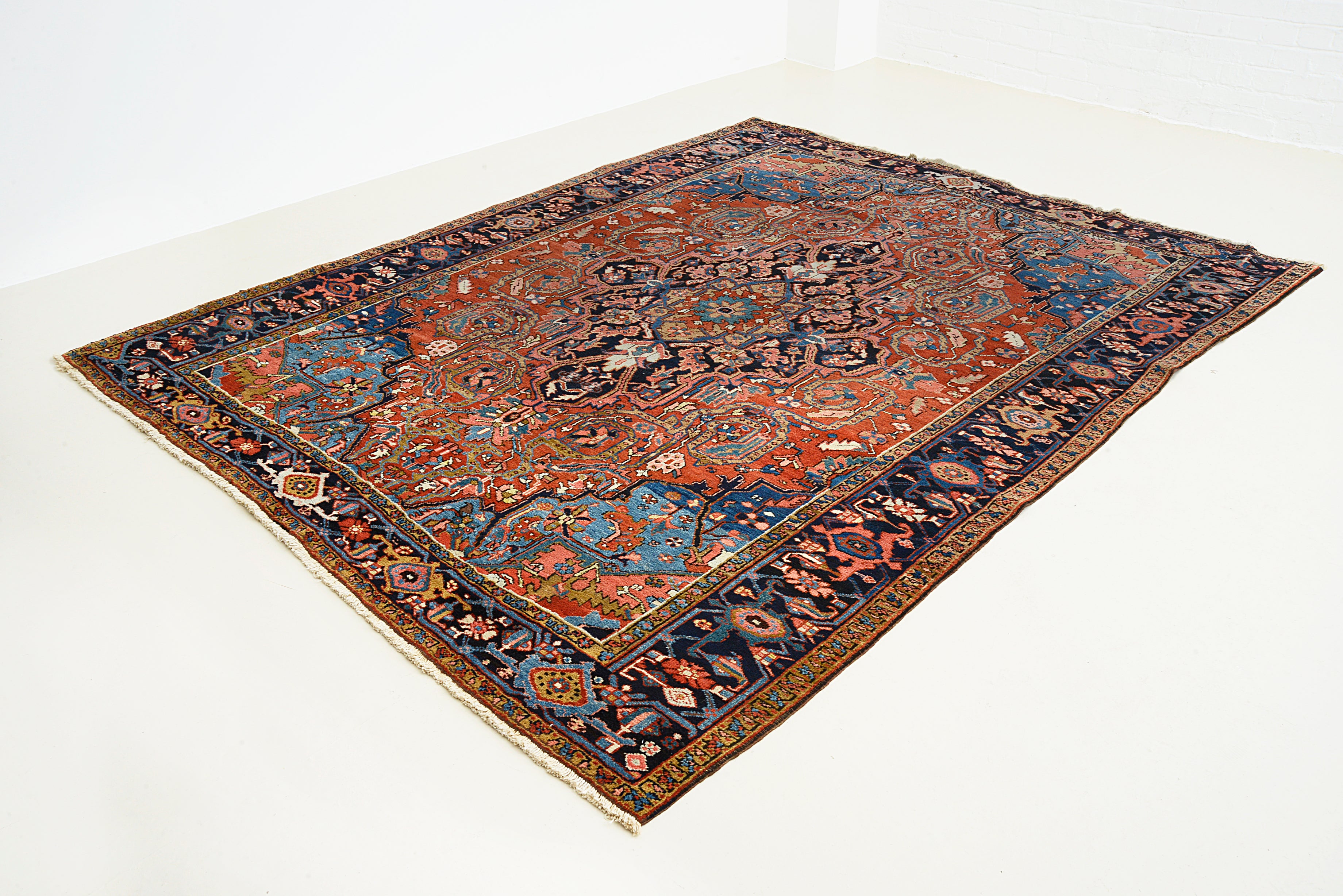 Perspective view of antique Persian Heriz carpet on floor