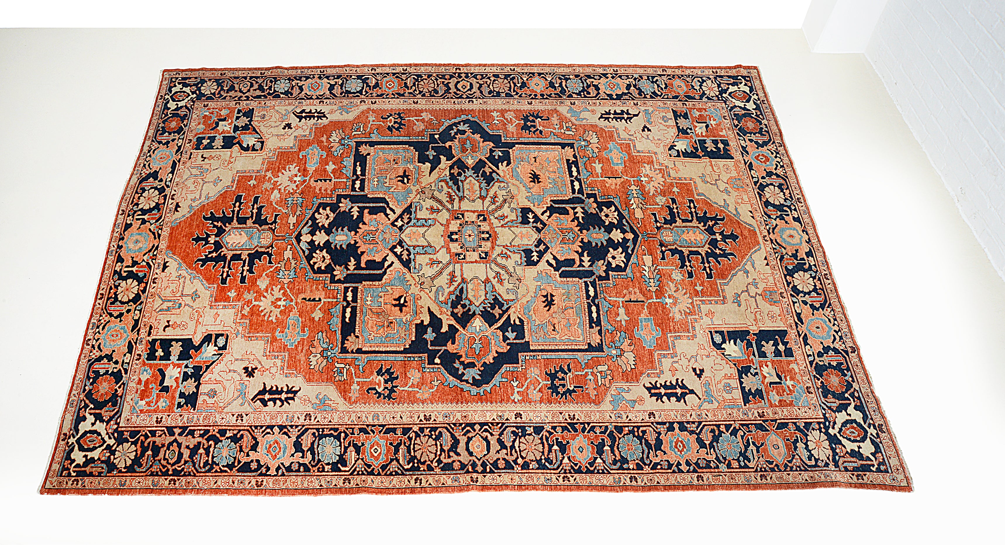 Angled view of vintage Persian Heriz Serapi carpet showing border design