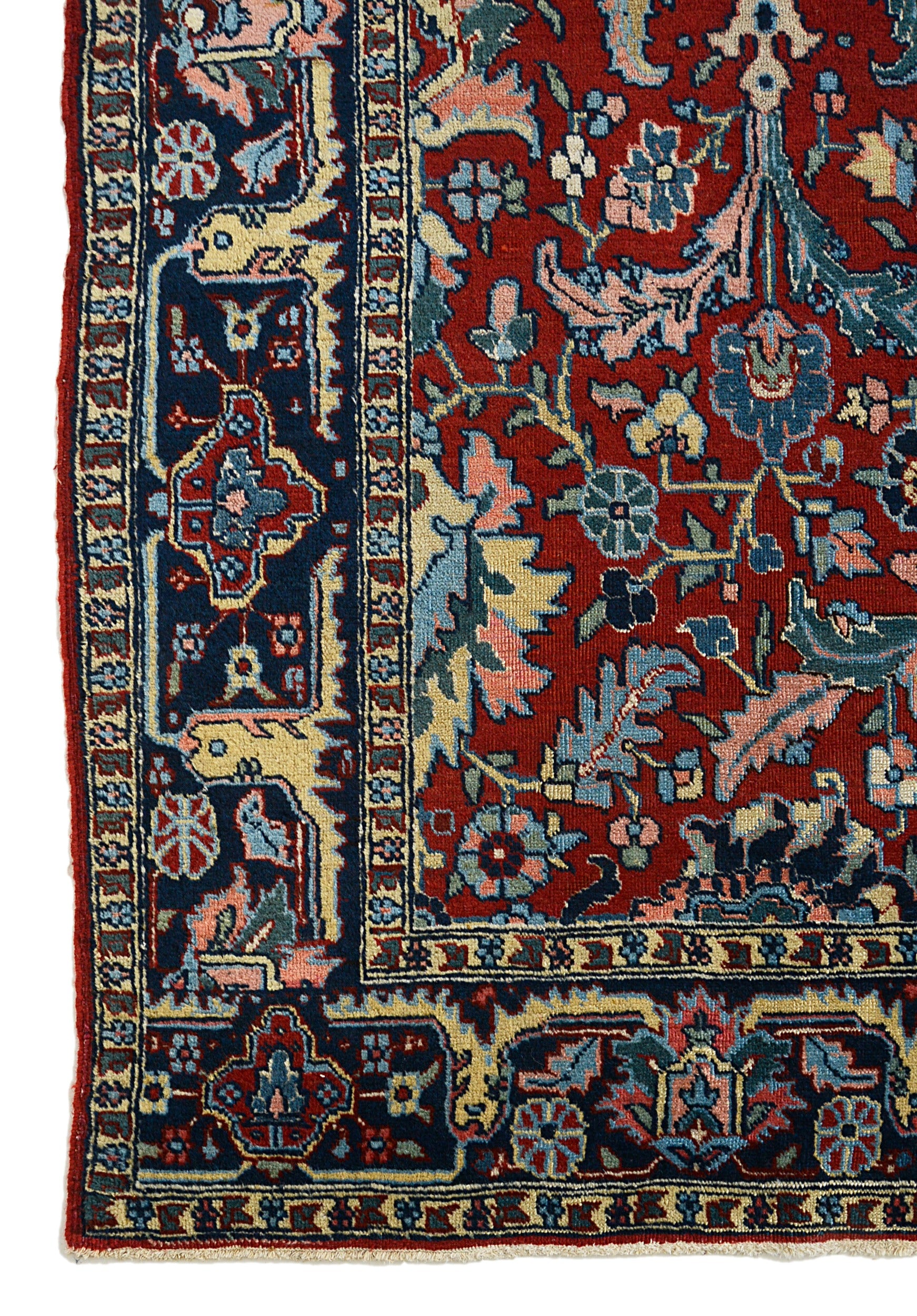 Antique Persian Heriz carpet corner detail showing hand-knotted wool and traditional floral border