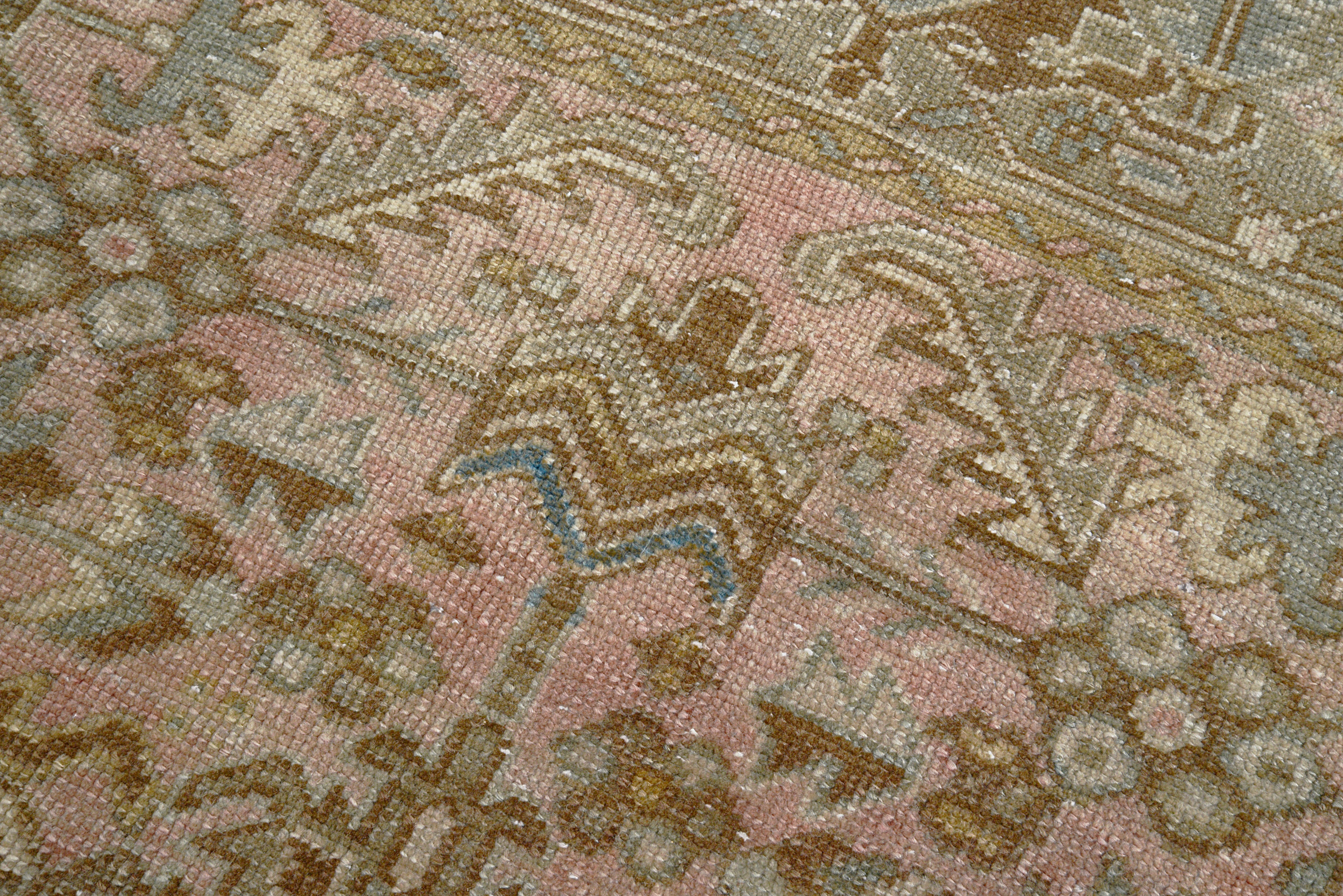 Detail of vintage Persian Heriz carpet showing wool texture, geometric motifs and natural colour variation from age and use