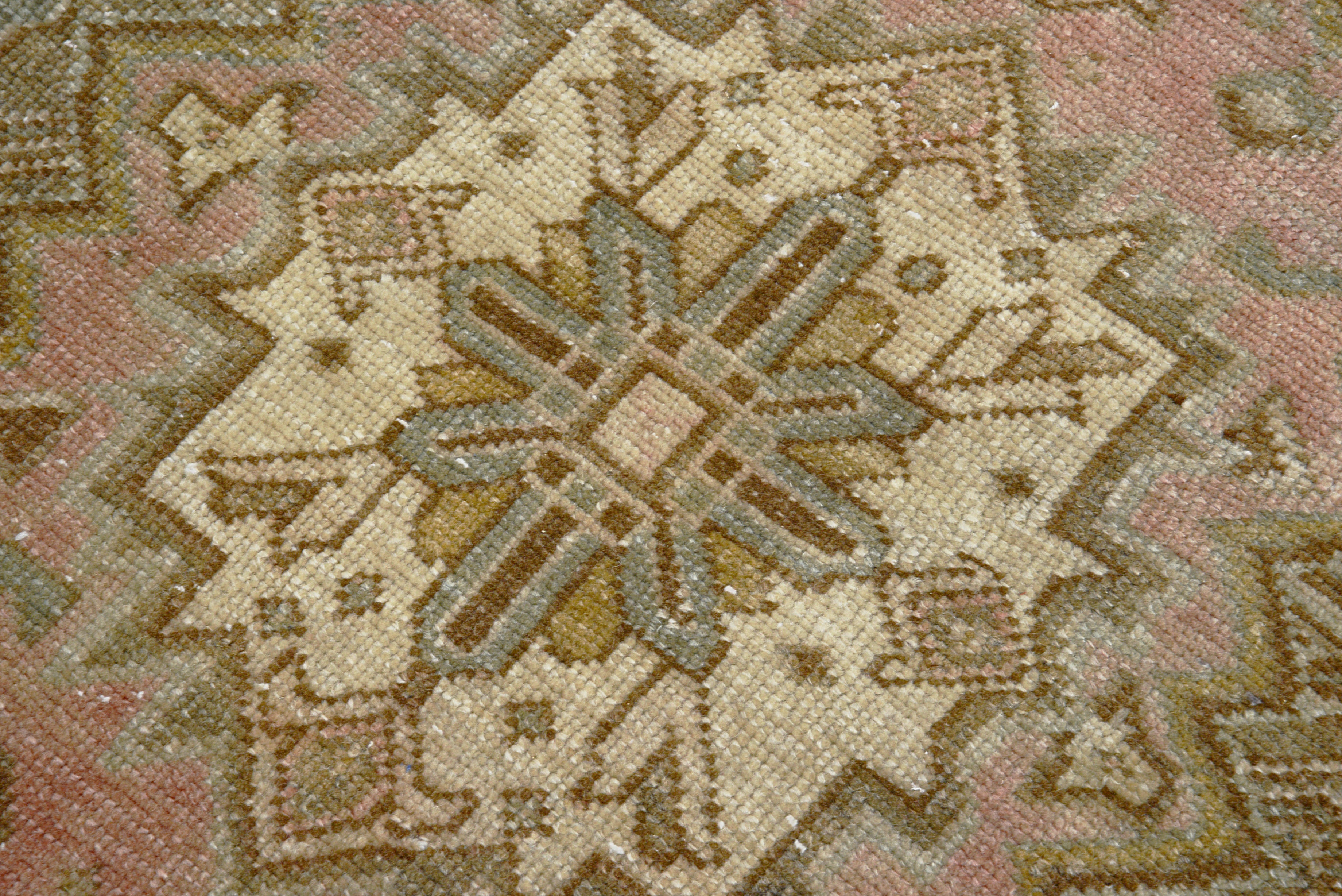 Detail of vintage Persian Heriz carpet showing wool texture, geometric motifs and natural colour variation from age and use
