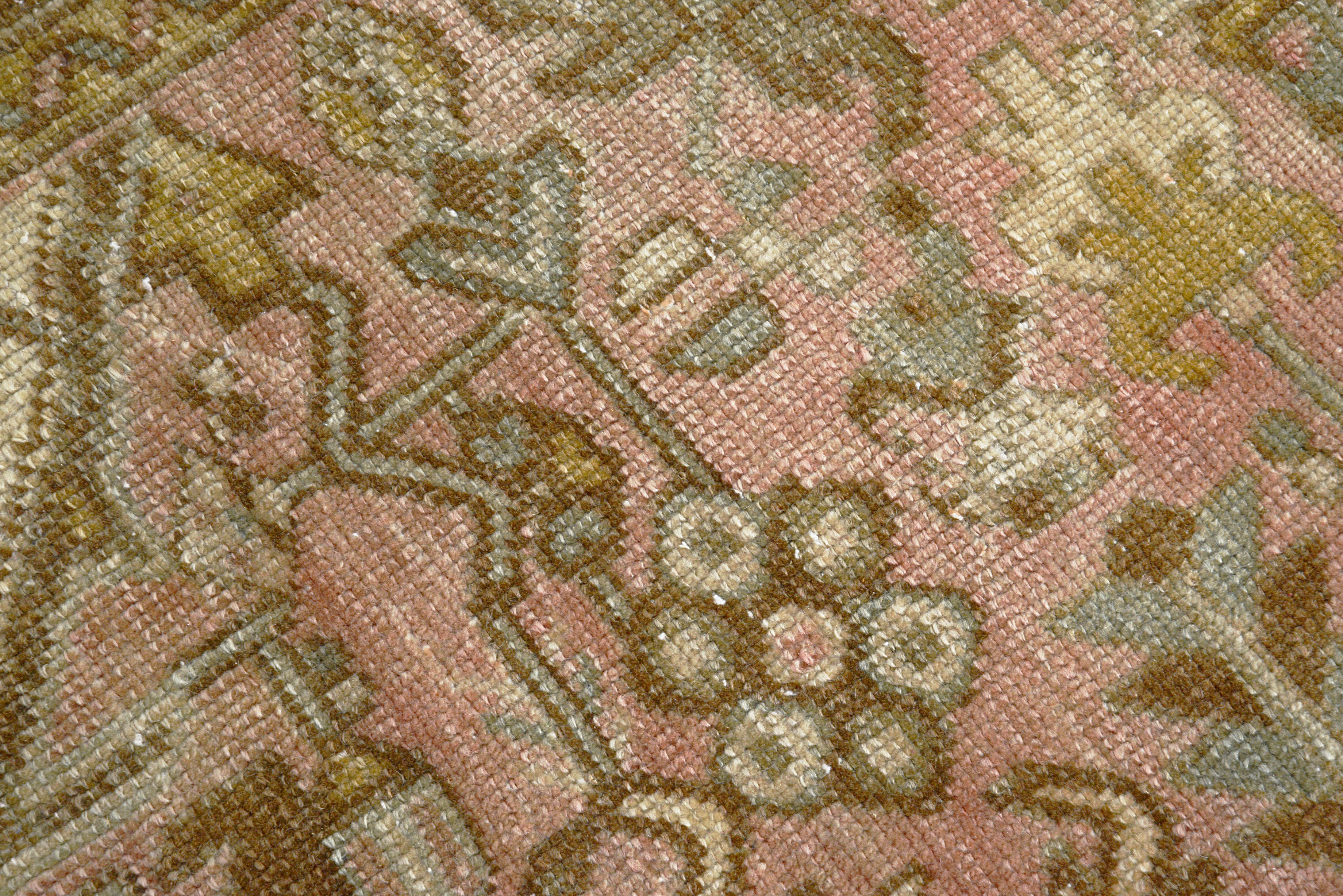 Detail of vintage Persian Heriz carpet showing wool texture, geometric motifs and natural colour variation from age and use
