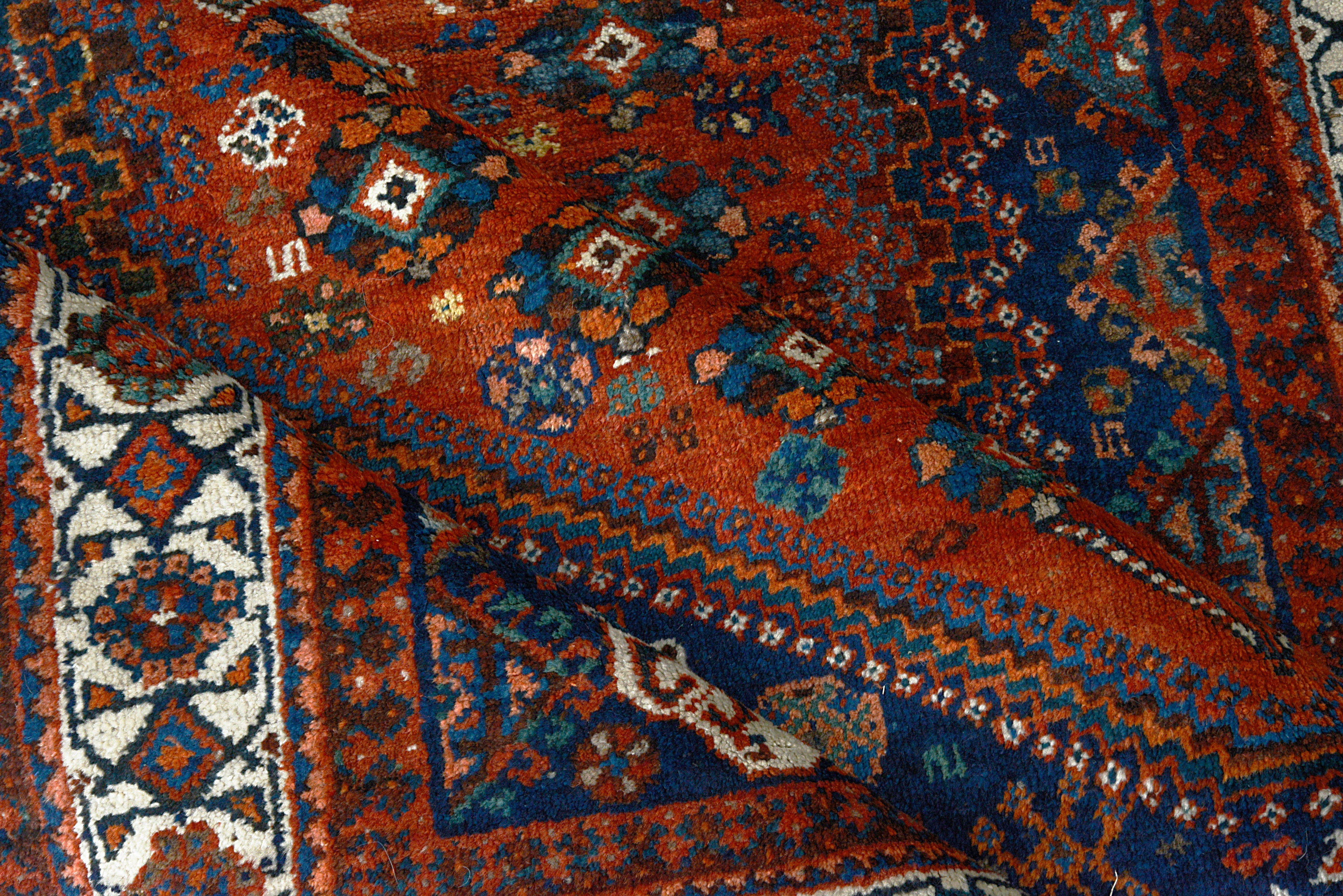 Close-up of an intricately designed Persian Qashqai rug with geometric patterns.