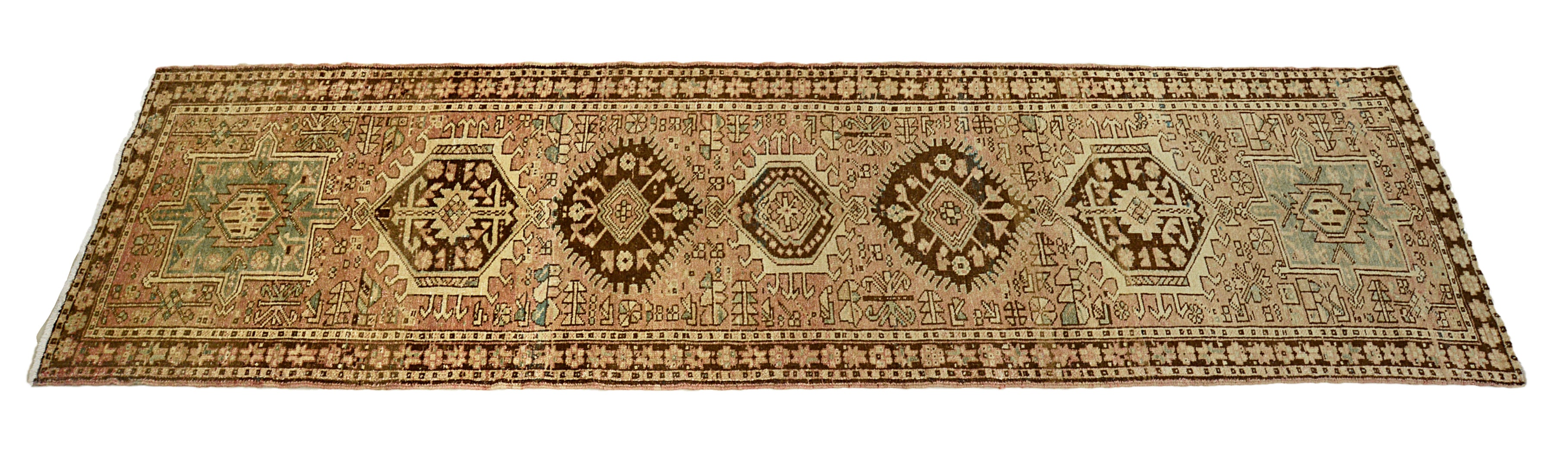 Antique Persian Heriz Runner with geometric patterns on a plain background