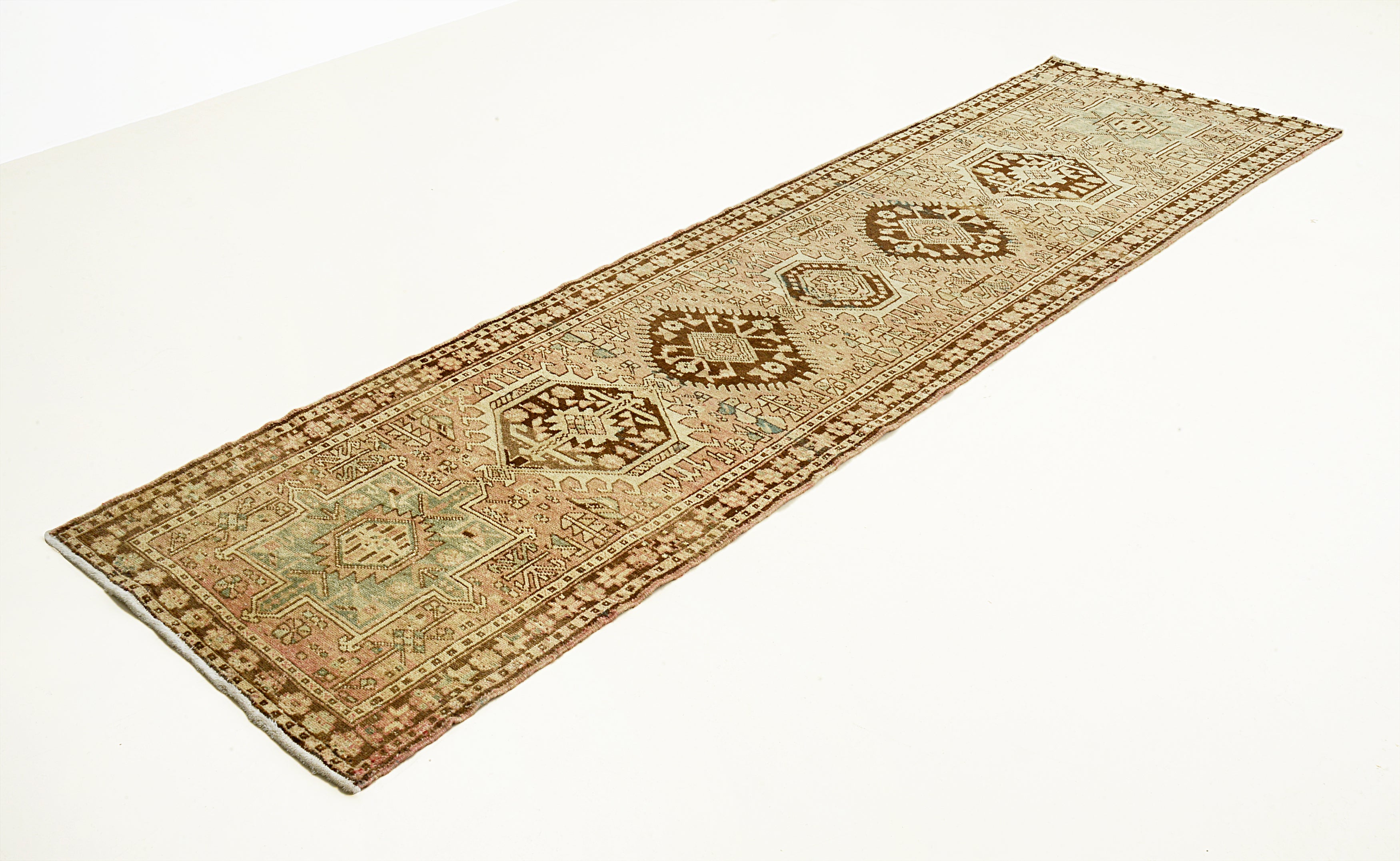 Long rectangular Persian Heriz Runner with decorative patterns on a white background