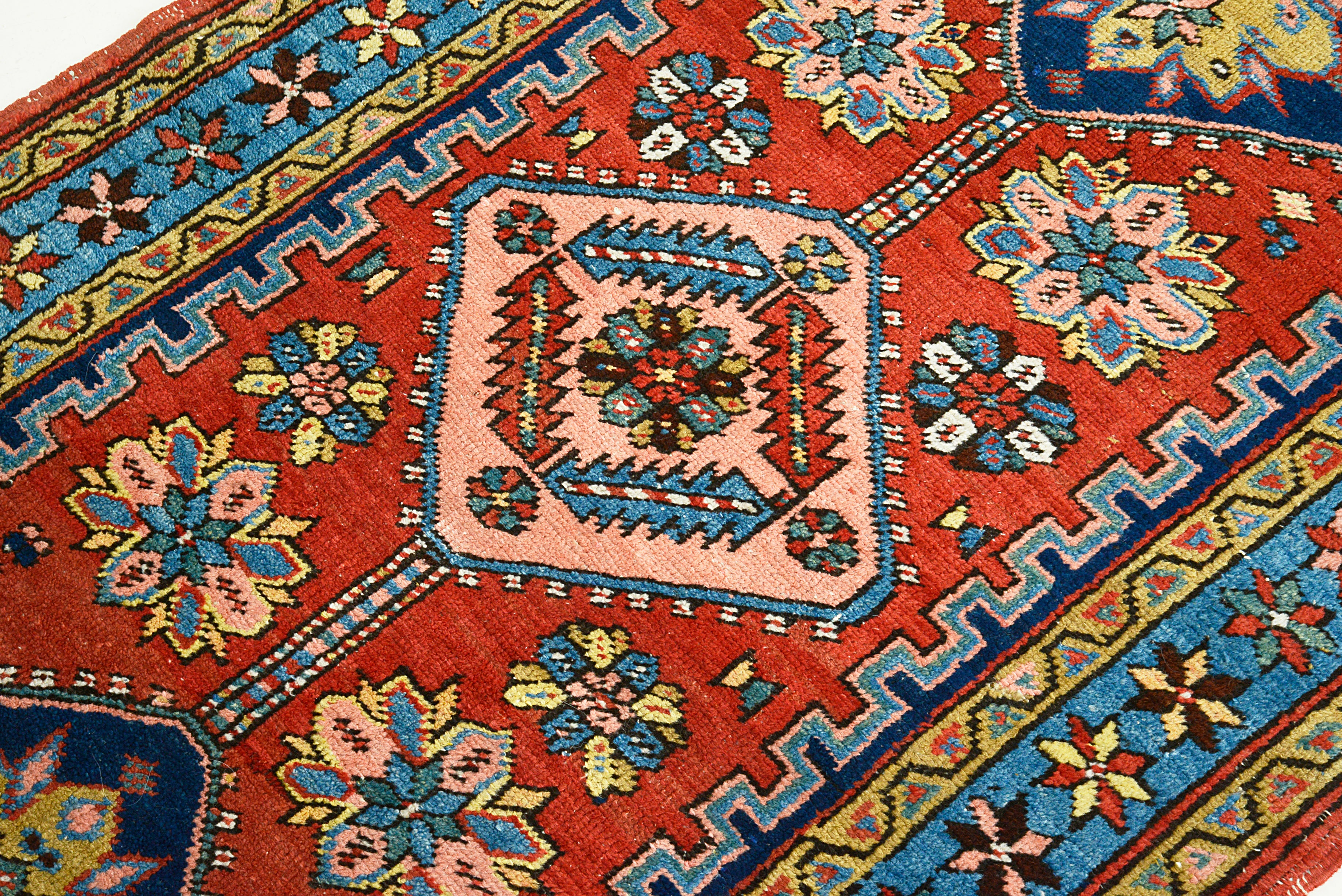 Close-up of a colorful patterned Heriz rug with geometric designs.