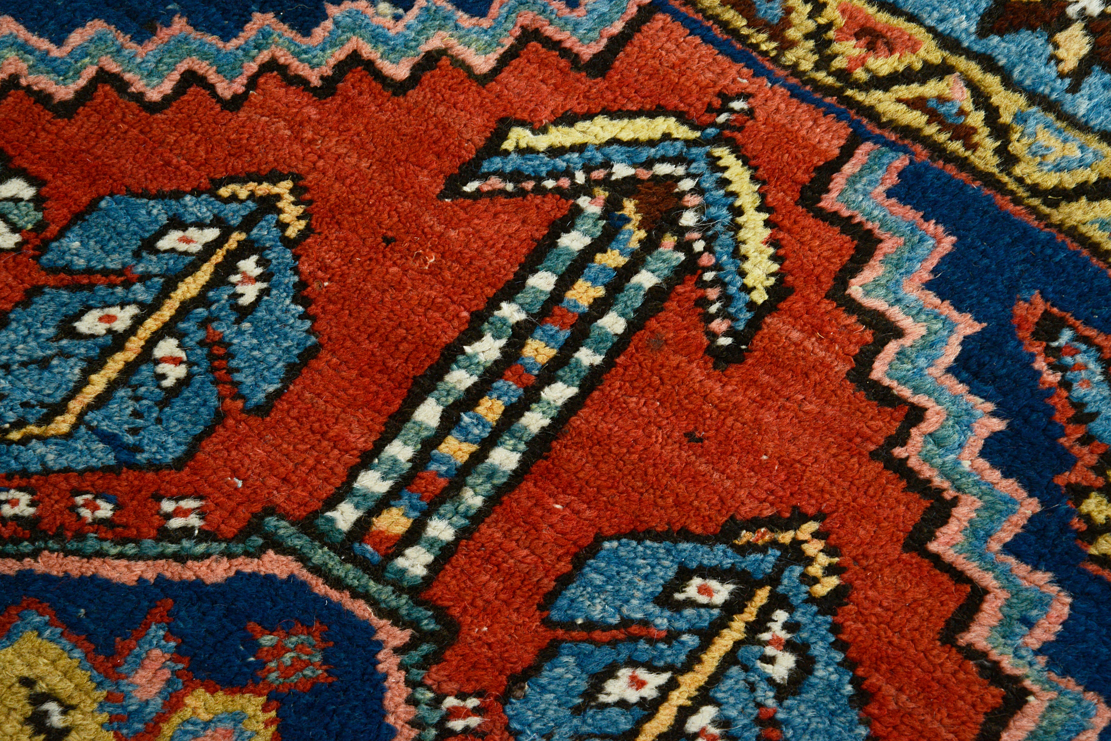 Close-up of a antique Persian Heriz rug with blue and red colors