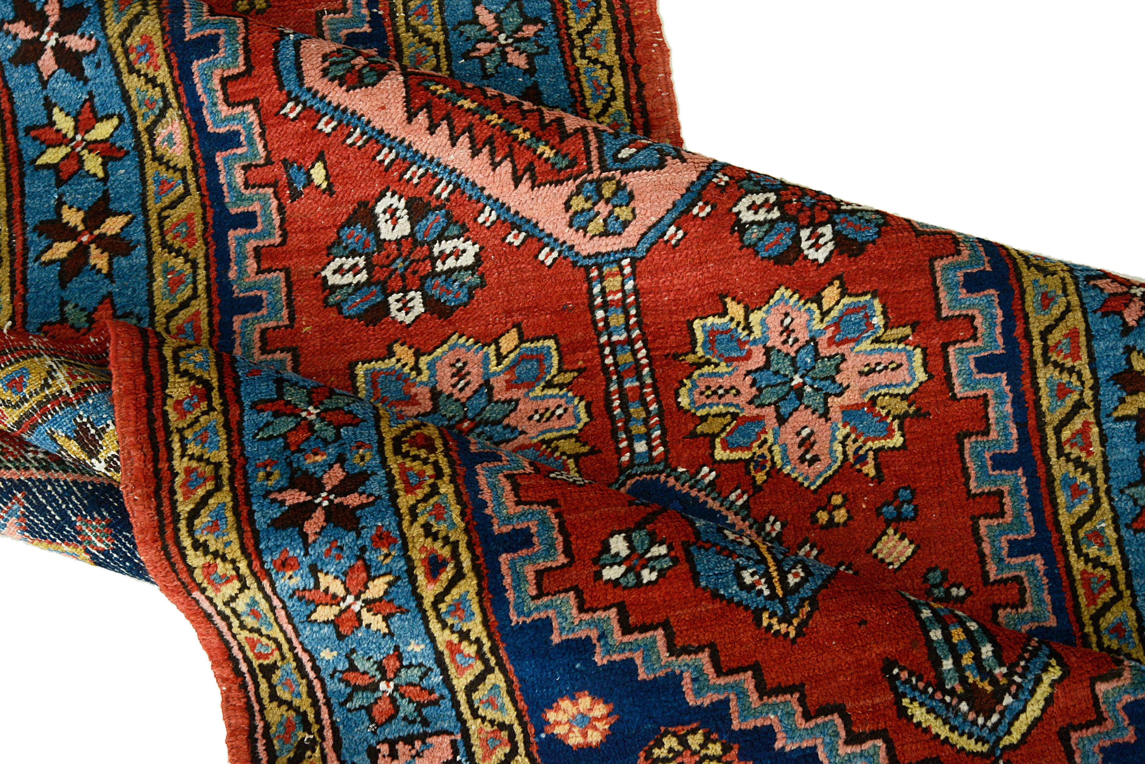 Close-up of Antique Persian Heriz rug with intricate designs on a white background