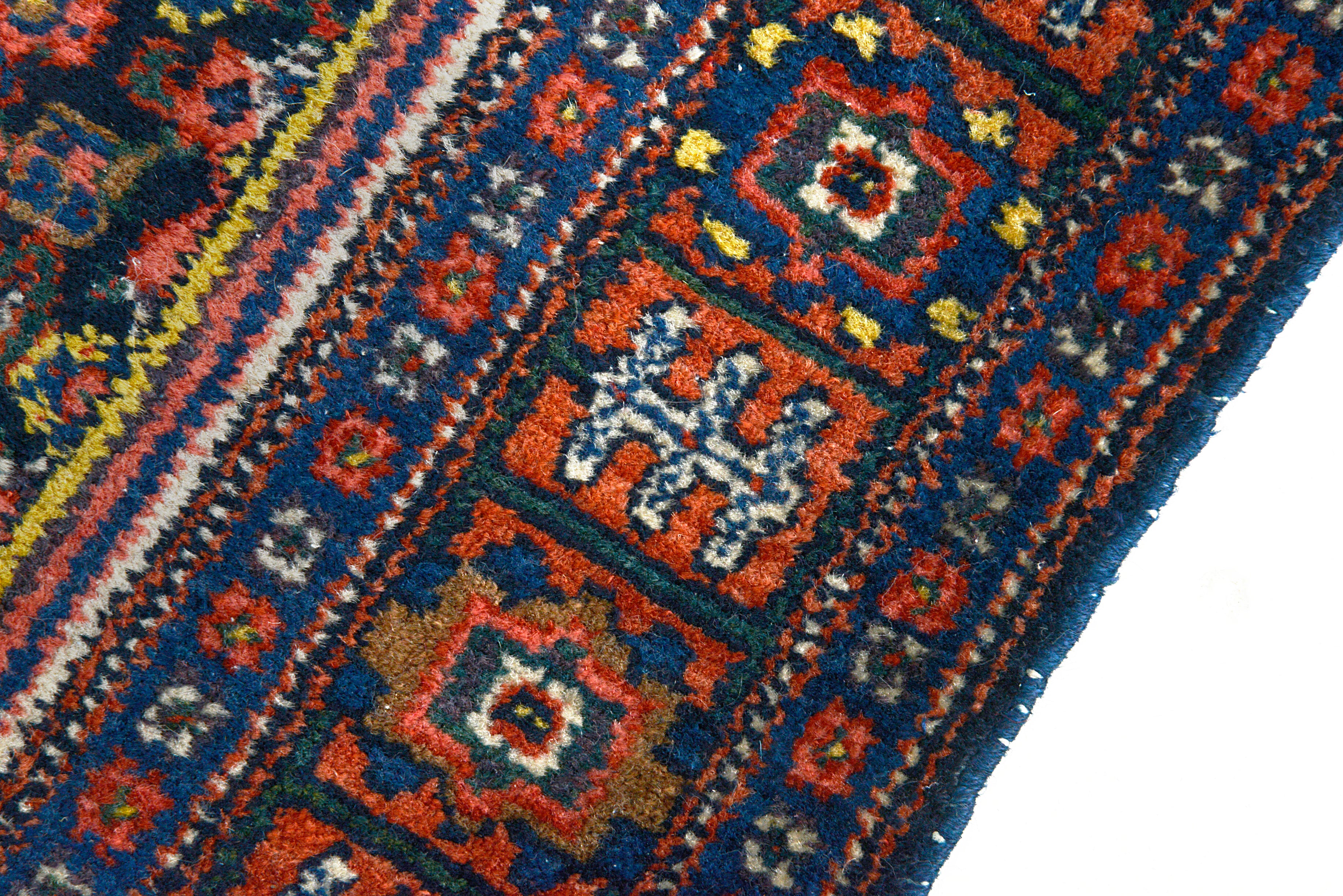 Close-up of a patterned rug with geometric designs in red, blue, and white.